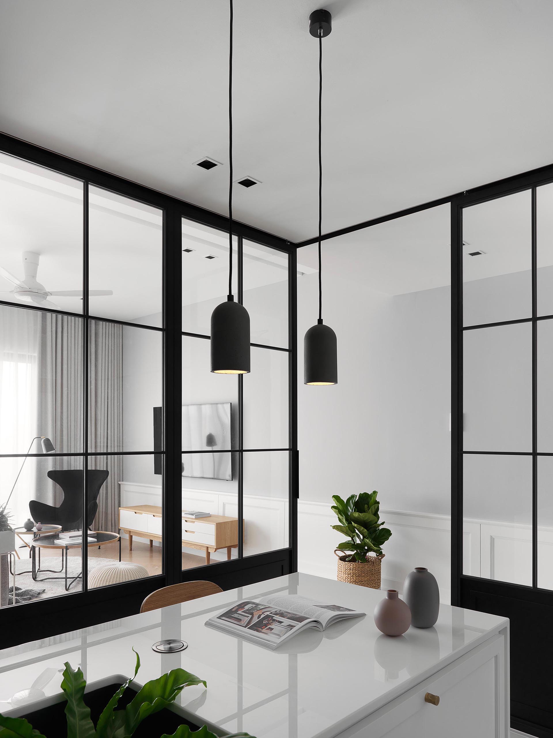 Sliding black-framed glass doors separate this modern kitchen from the living room and dining room.