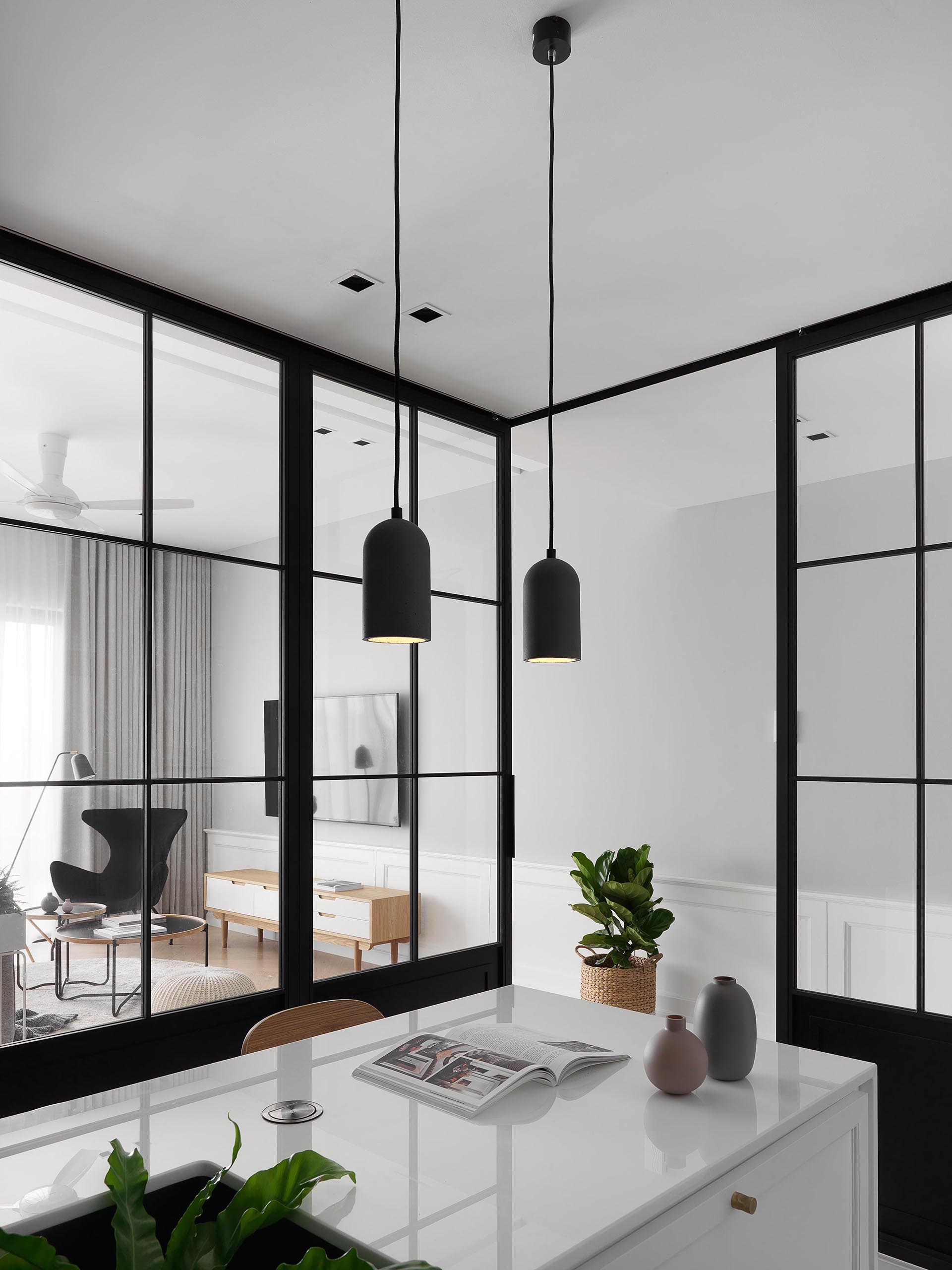 Sliding black-framed glass doors separate this modern kitchen from the living room and dining room. 