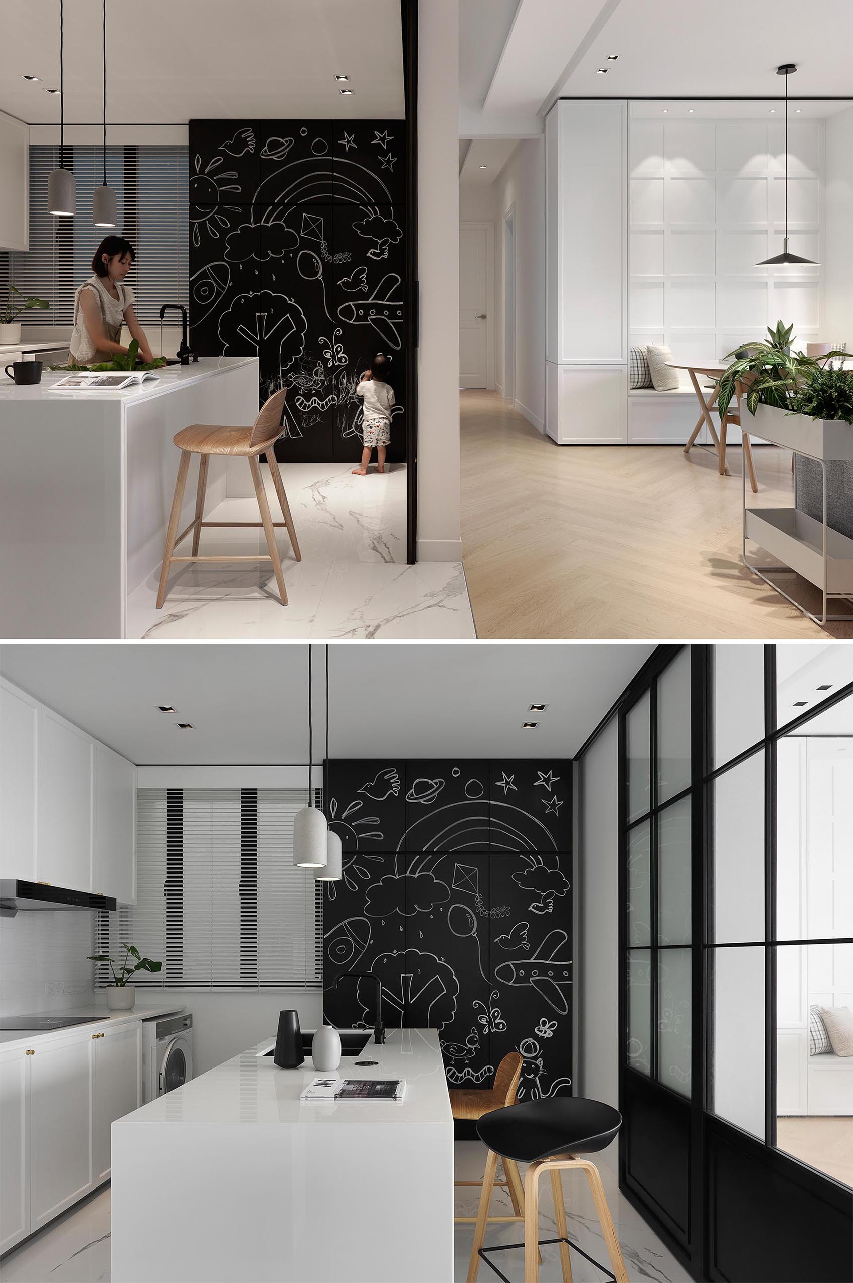 This minimalist kitchen features white cabinets and a white island, as well as a contrasting section of cabinets with chalkboard fronts.