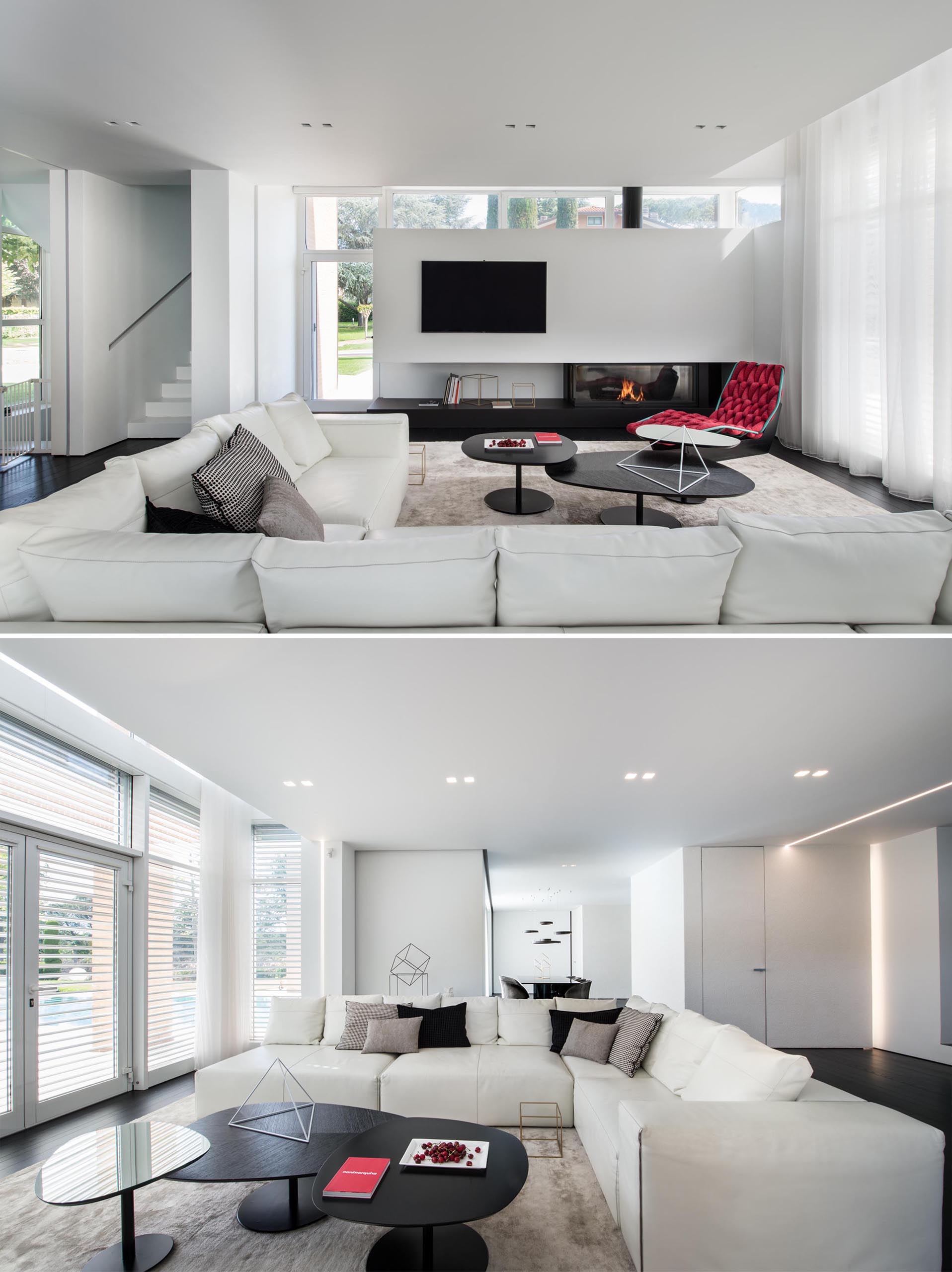 In this modern living room, a white corner sofa sits on top of a large rug, while black coffee tables complement the black fireplace. A woven red chaise has been chosen to add a touch of color.