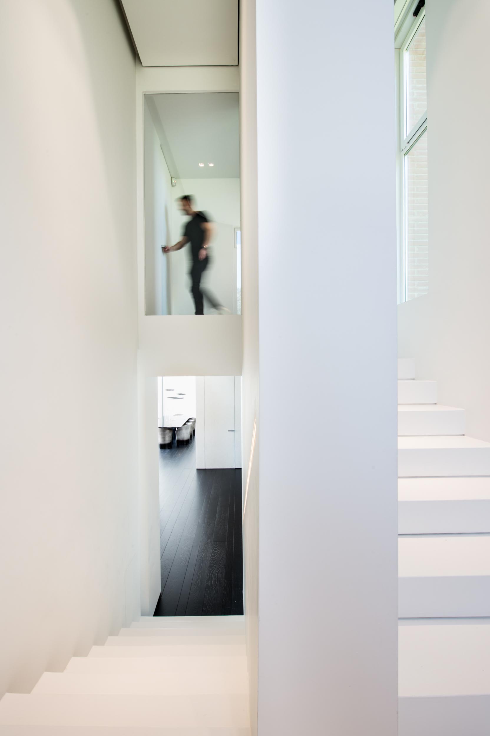 A white staircase that helps to keep the space bright, while a built-in handrail also has LED lighting hidden from view.