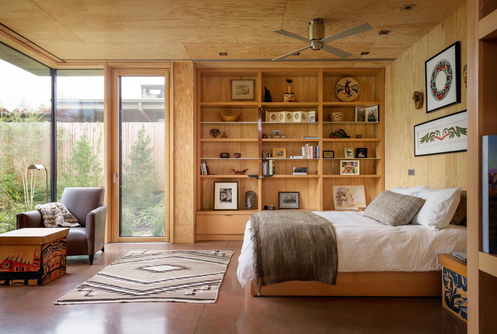 A bedroom with concrete floors and wood shelving.