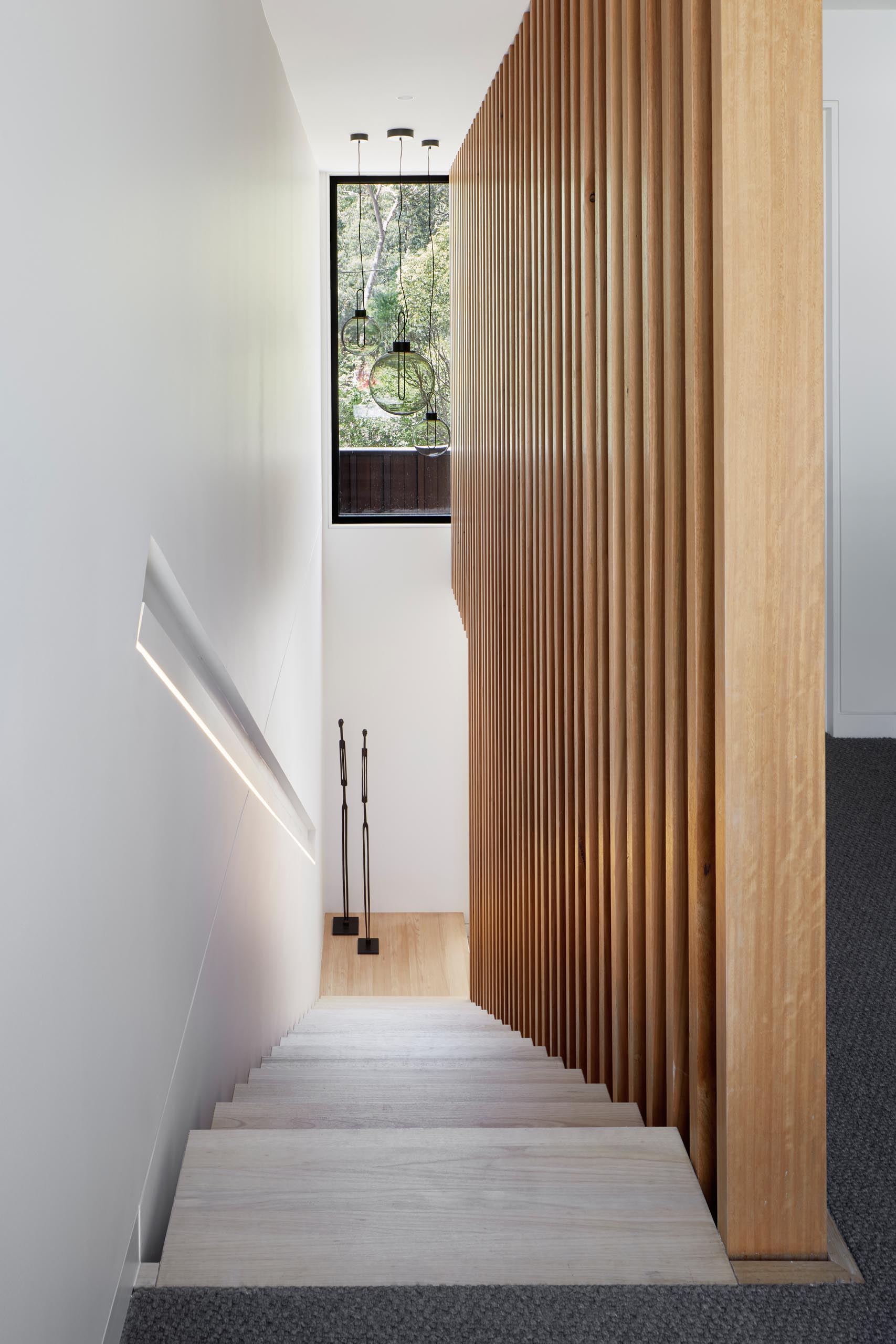 Modern wood stairs with a built-in handrail with lighting.