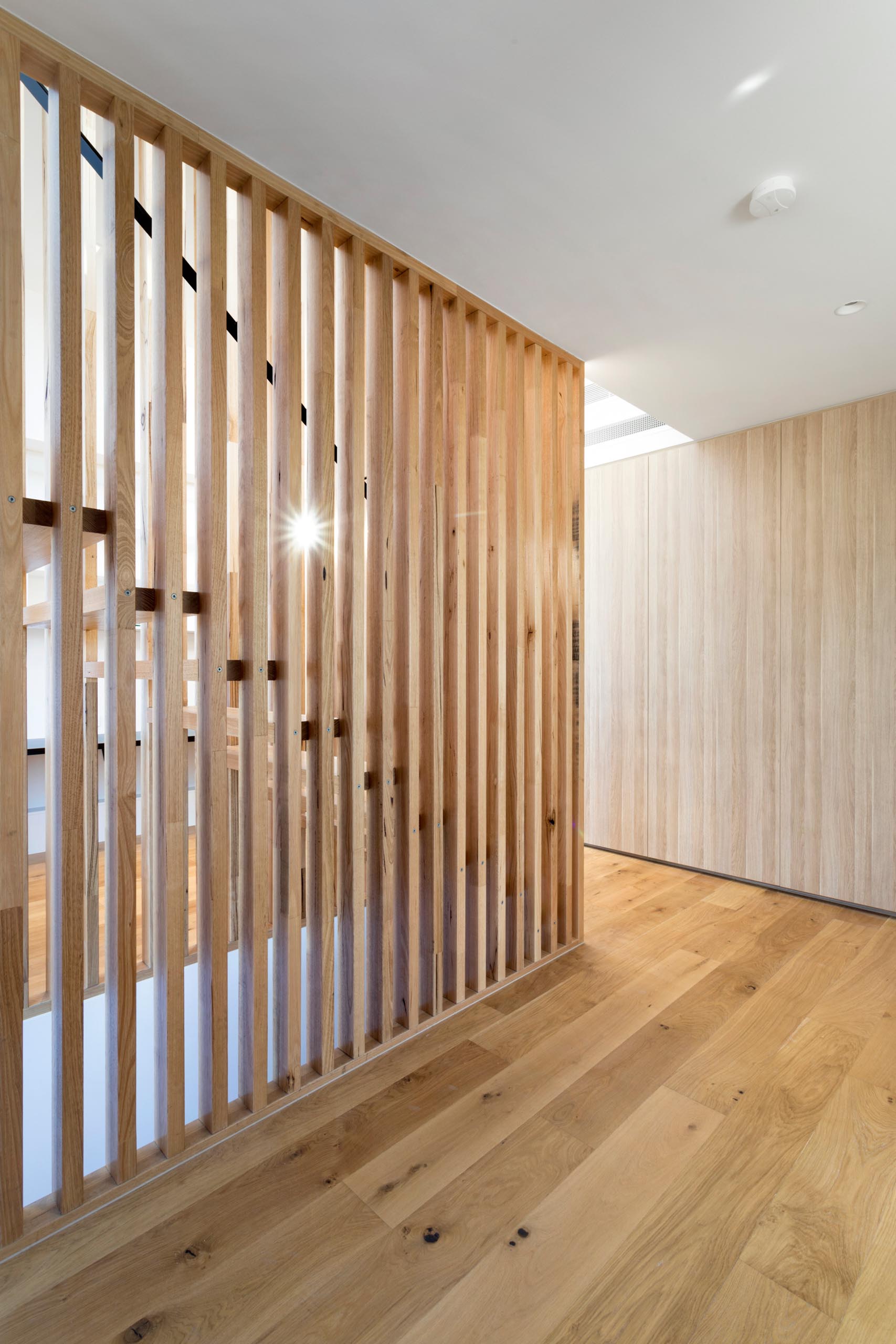This staircase has solid timber stair tread that sit perfectly in between long vertical timber battens without the need for stair stringers.