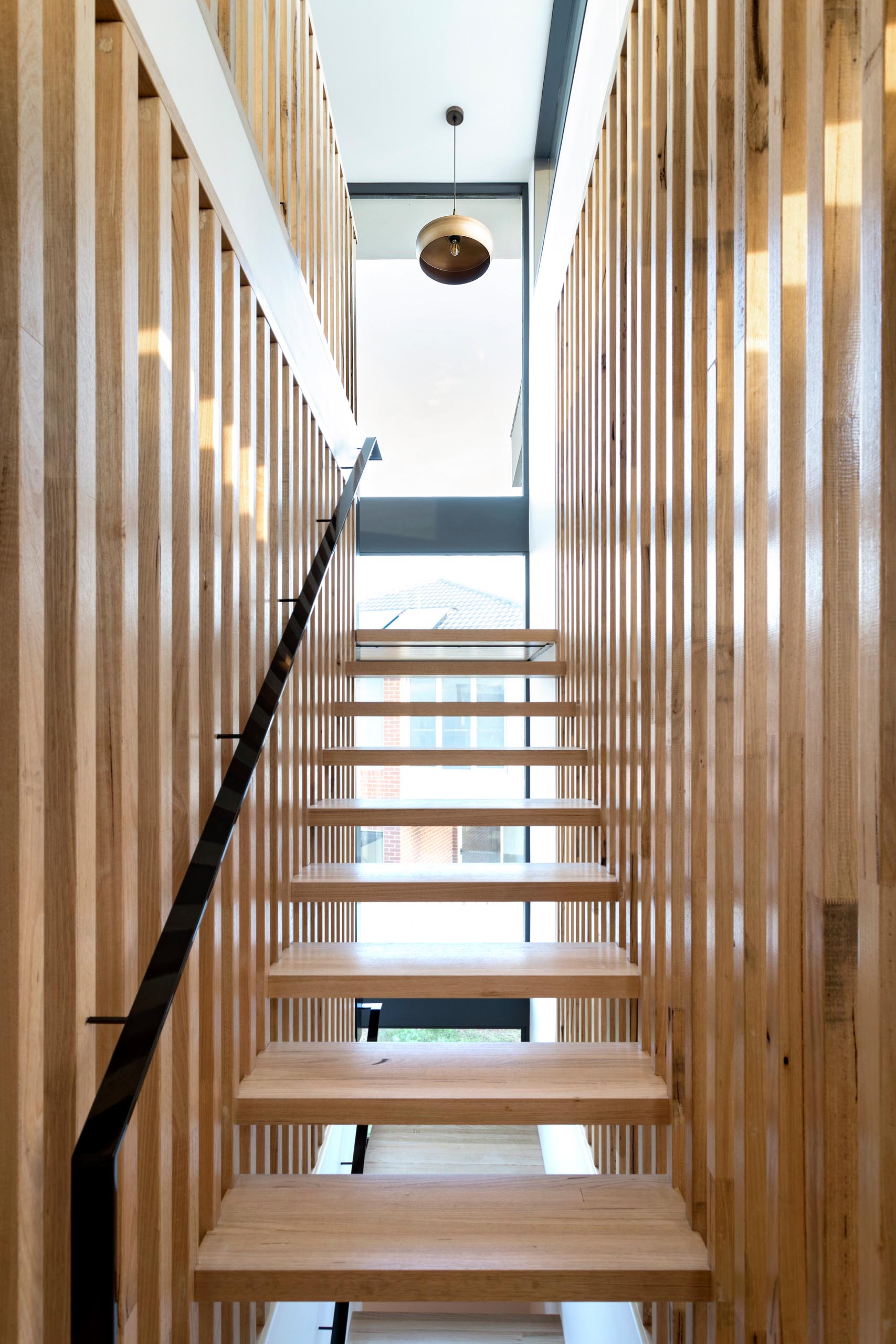 This staircase has solid timber stair tread that sit perfectly in between long vertical timber battens without the need for stair stringers.