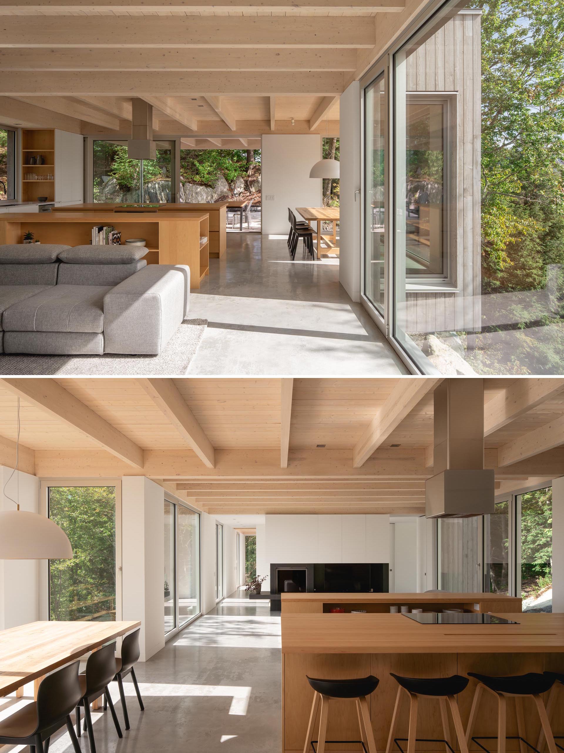 In this modern kitchen, there's two kitchen islands made from solid maple, polished concrete floors, and a large square window above the sink.