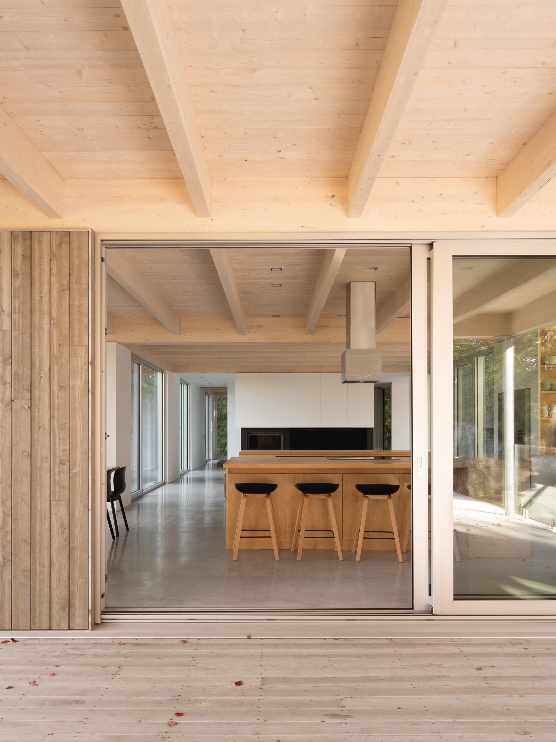 A large sliding door opens the interior spaces of this modern home to a partially covered terrace.