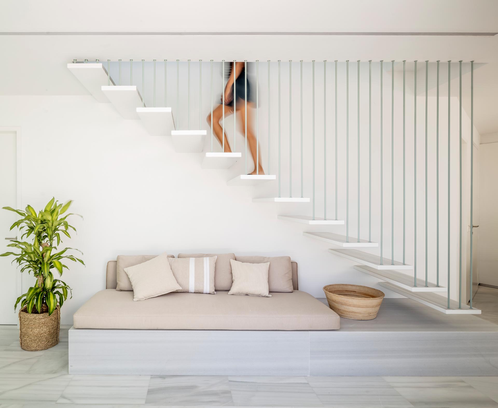 A locally sourced marble and upholstered cushions have been used to create a comfortable seating nook underneath the stairs.