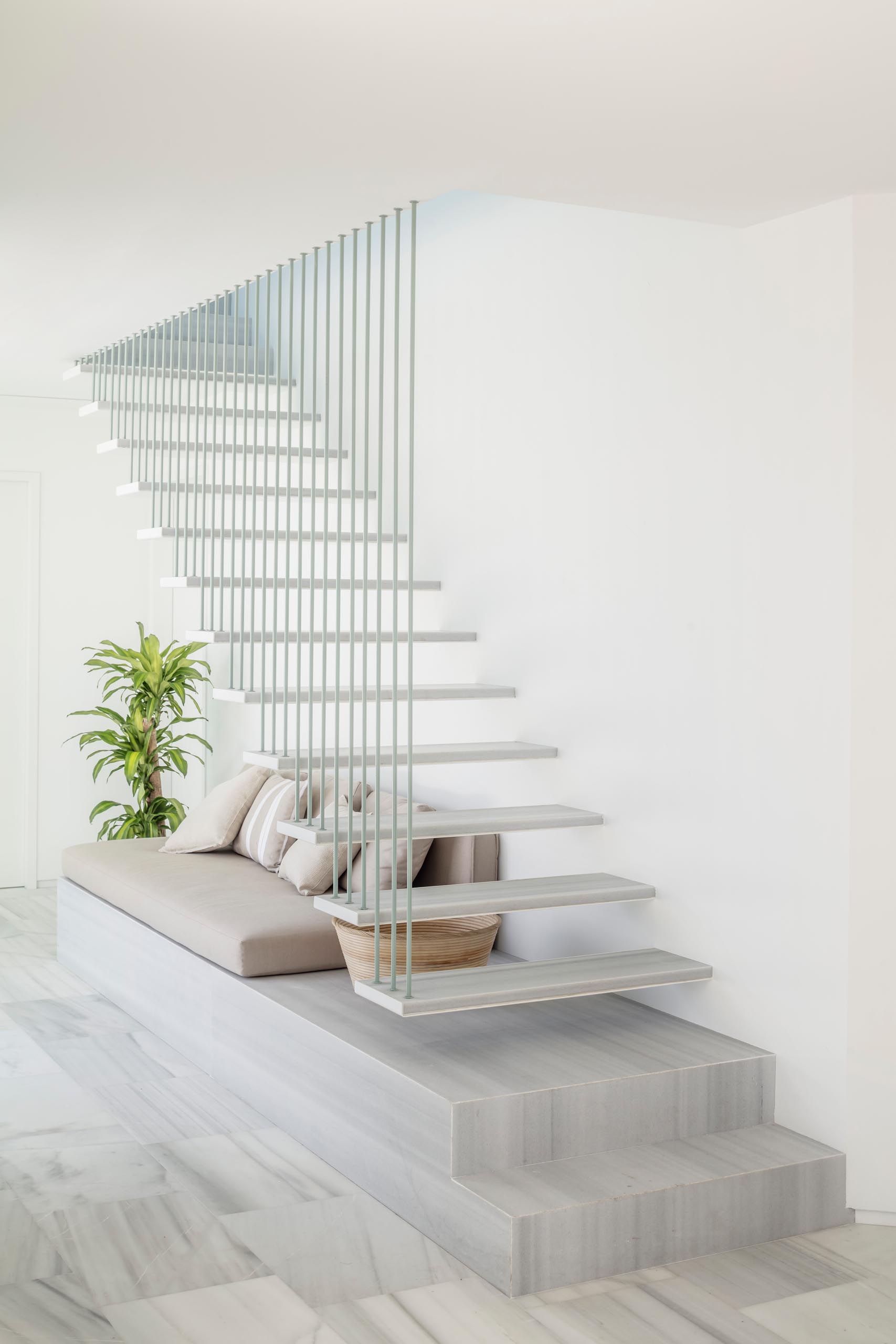 A modern staircase with marble stair treads and a seating nook.