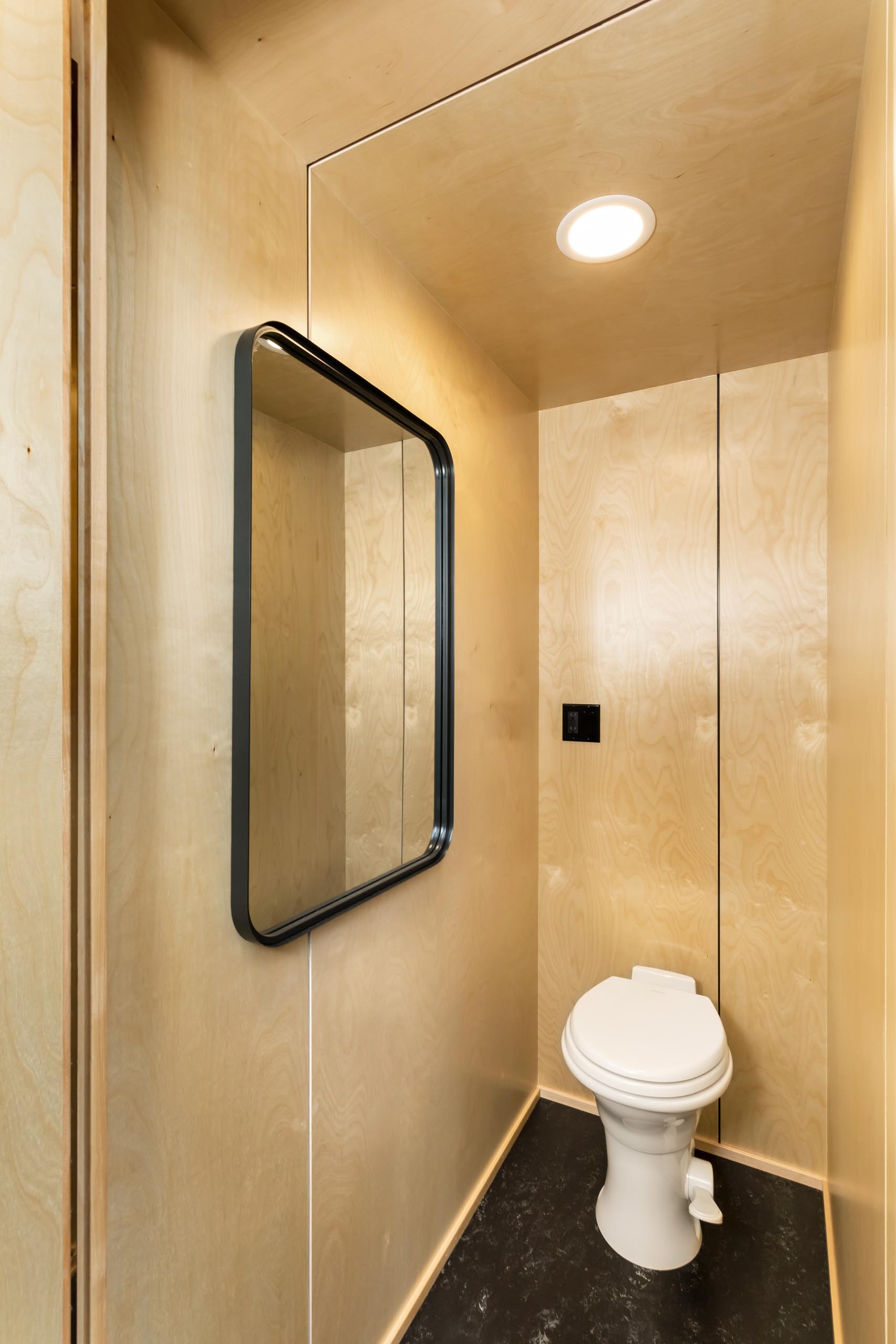 A simple wood-lined tiny home bathroom.