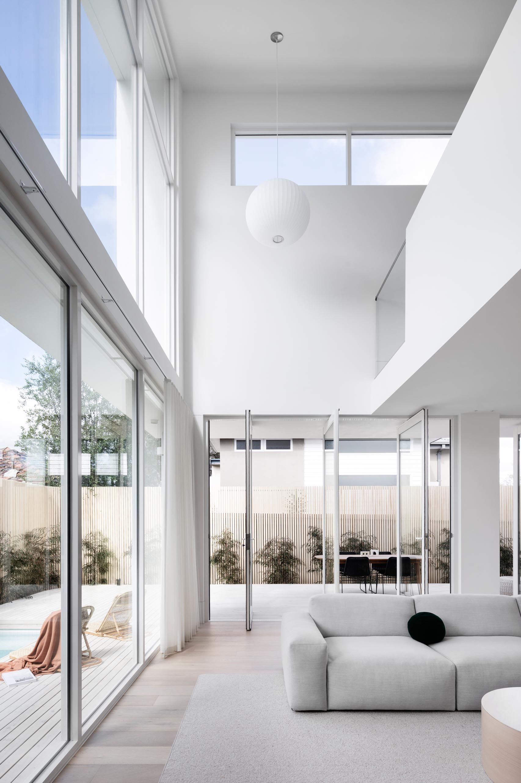 Pivoting sections of glass walls connect the interior spaces with the outdoors of this modern house.