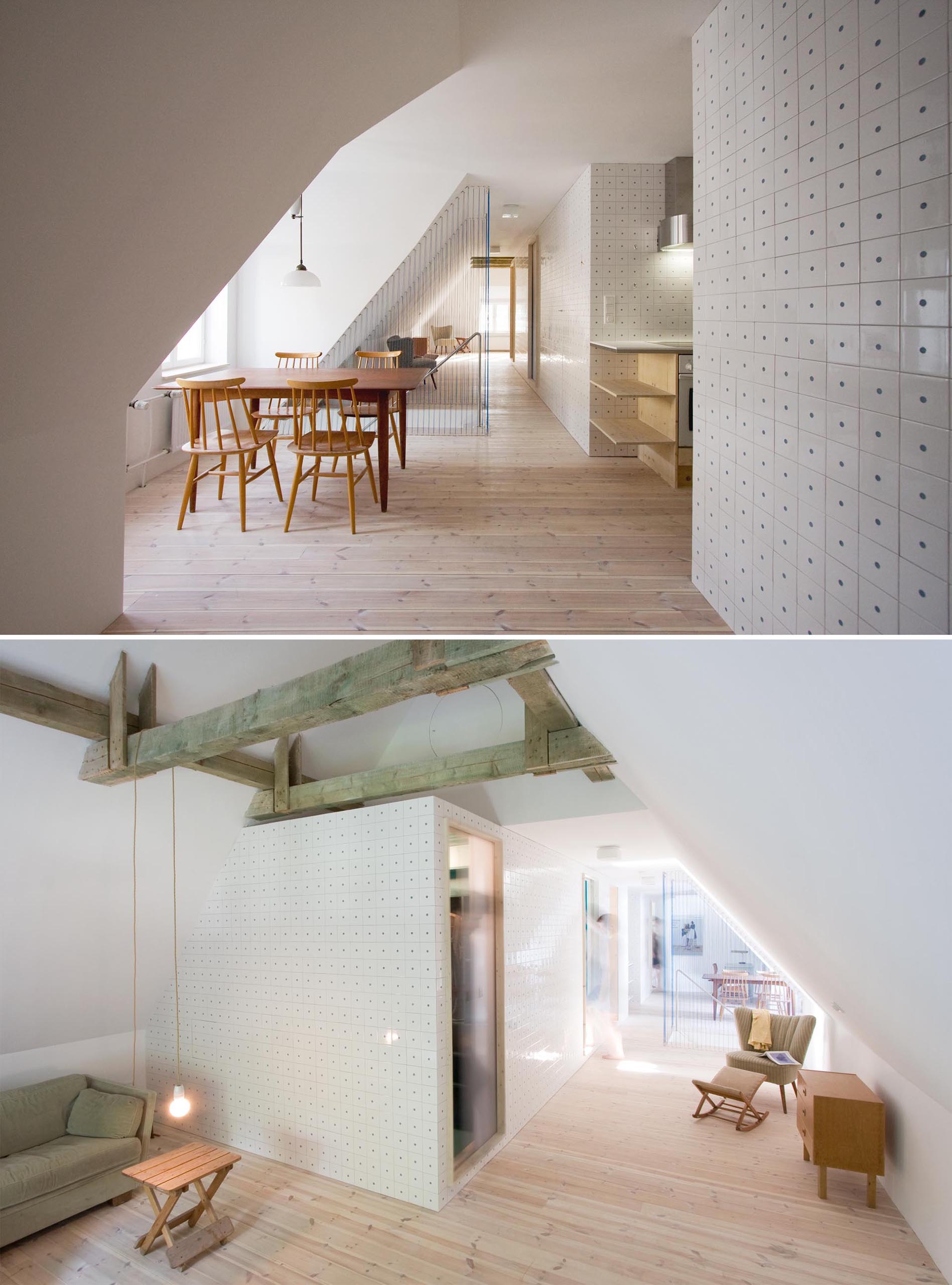 A bright attic with tiled walls, a dining area, a kitchen, and blue rope safety barrier for the stairs.