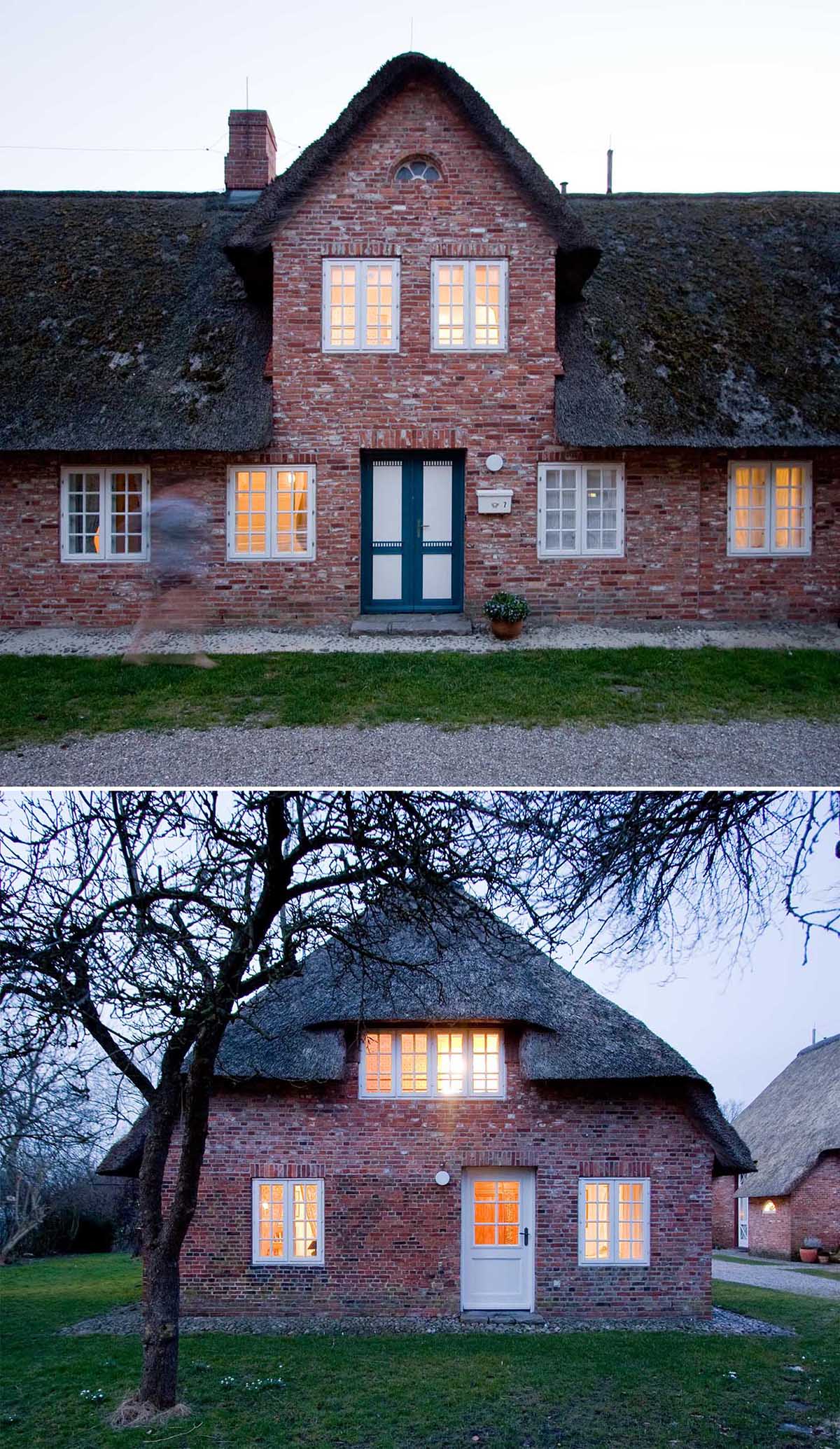 A brick house with a thatched roof and white window frames.