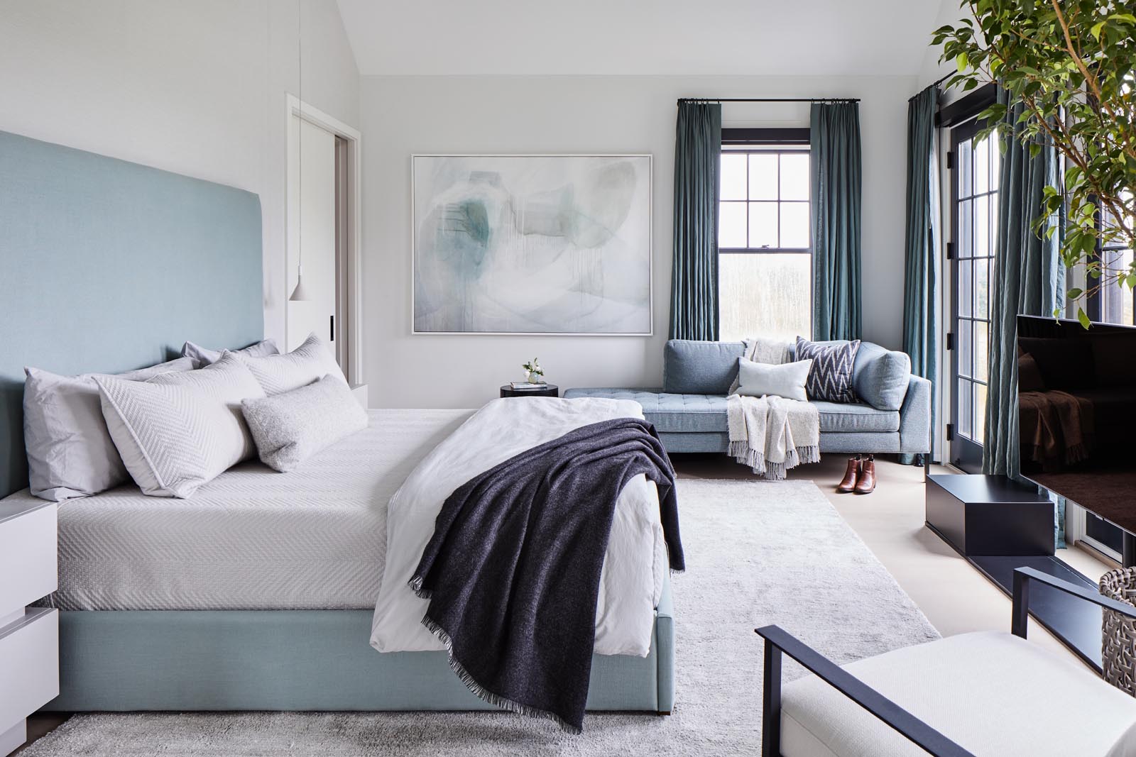 A sun-soaked master bedroom was designed with a calming light blue color palate inspired by the home’s natural surroundings.