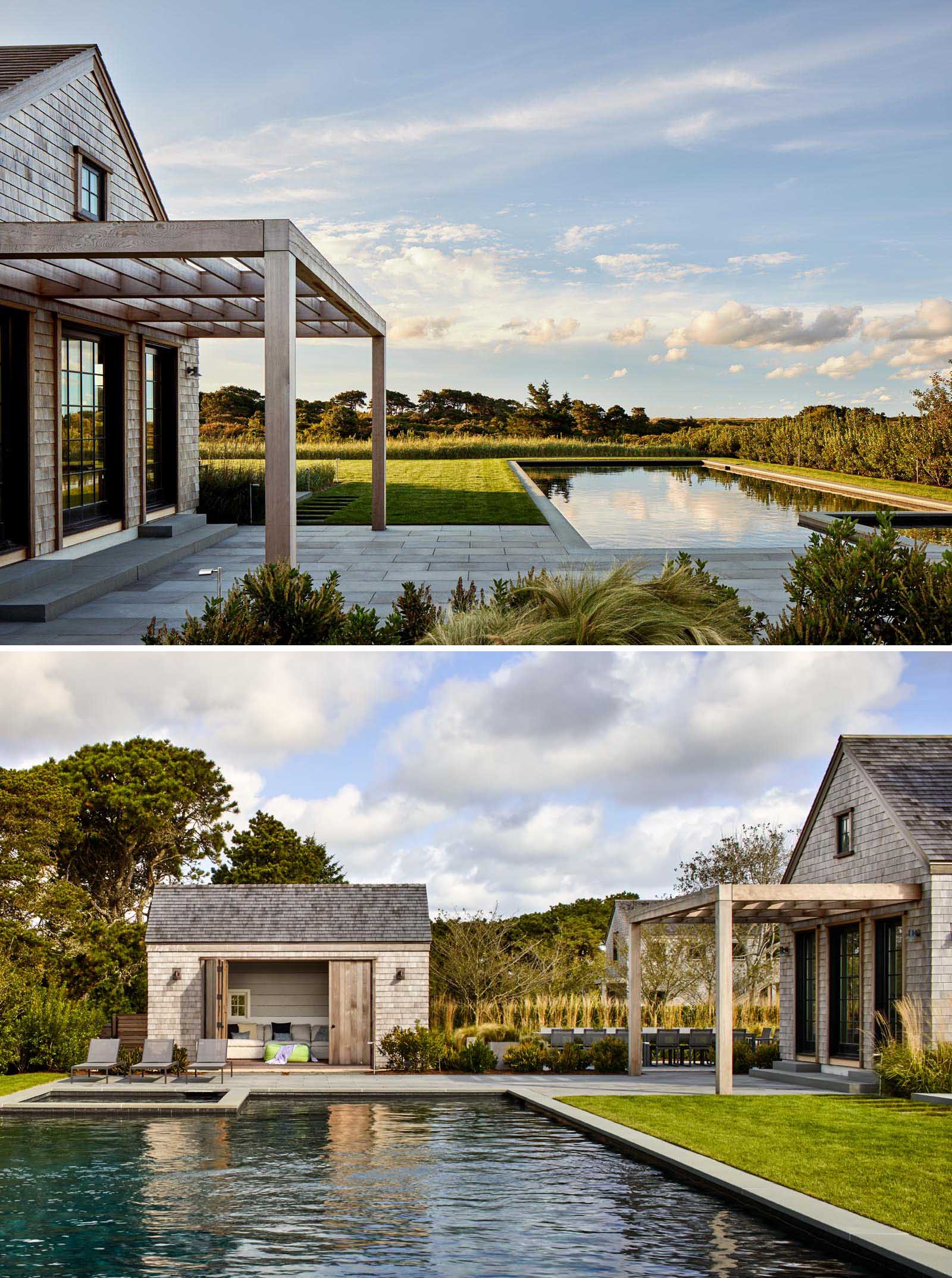 A modern house with shingle siding and a swimming pool.