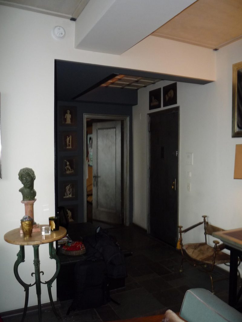 A 'before' photo of a dark entryway before being remodeled into a modern and bright space.