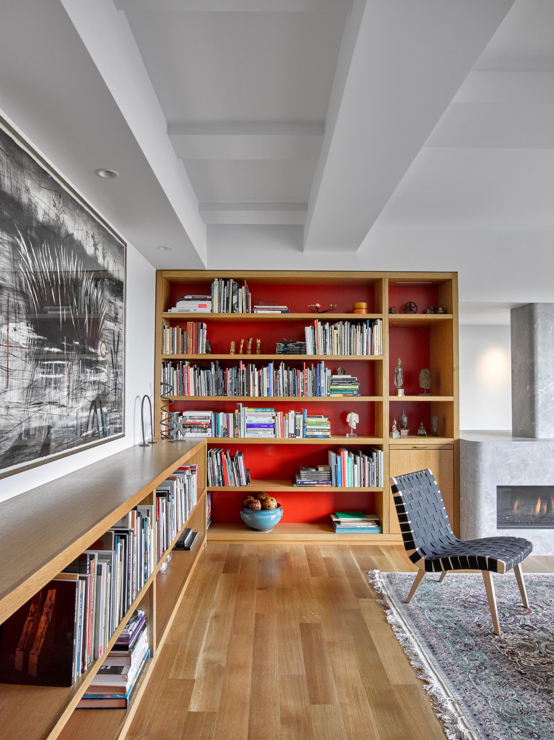 A custom wood shelving unit runs along the wall and transitions into a bookshelf with LED lighting.