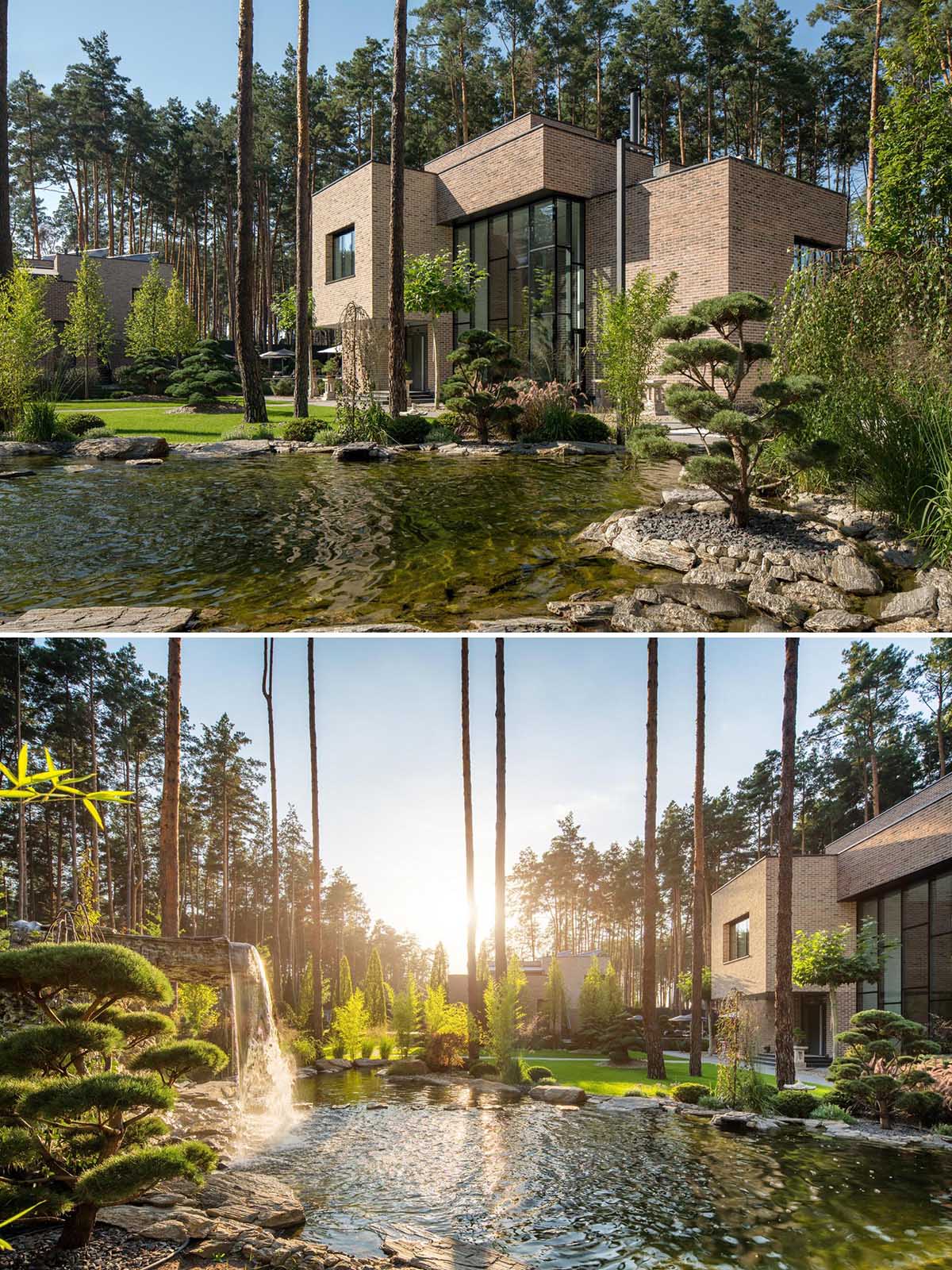 The landscape design of this modern brick house includes a natural pond with a waterfall.