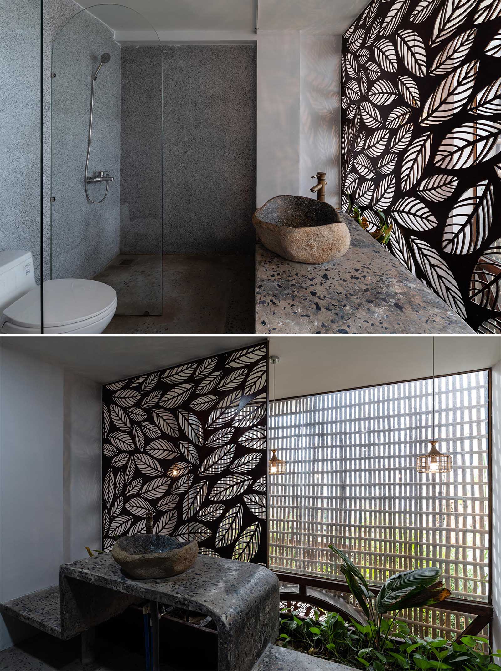 In this modern bathrooms, a decorative metal screen with a leaf motif has been used as a backdrop for vanity and as a way to highlight the doorway.