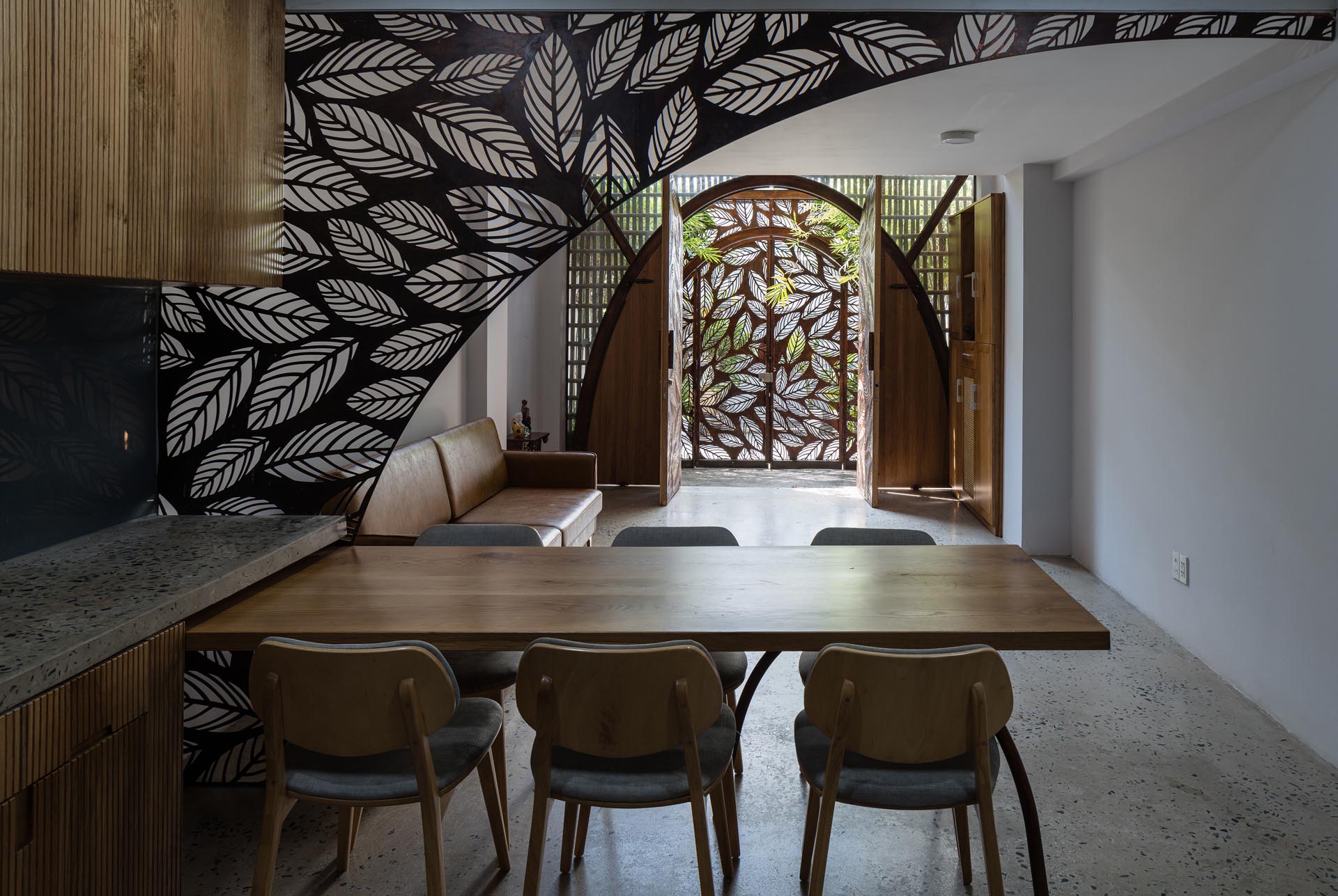 Stepping through to the interior of this modern house, there's a partial screen that acts as a divider between the living room and the dining area / kitchen.