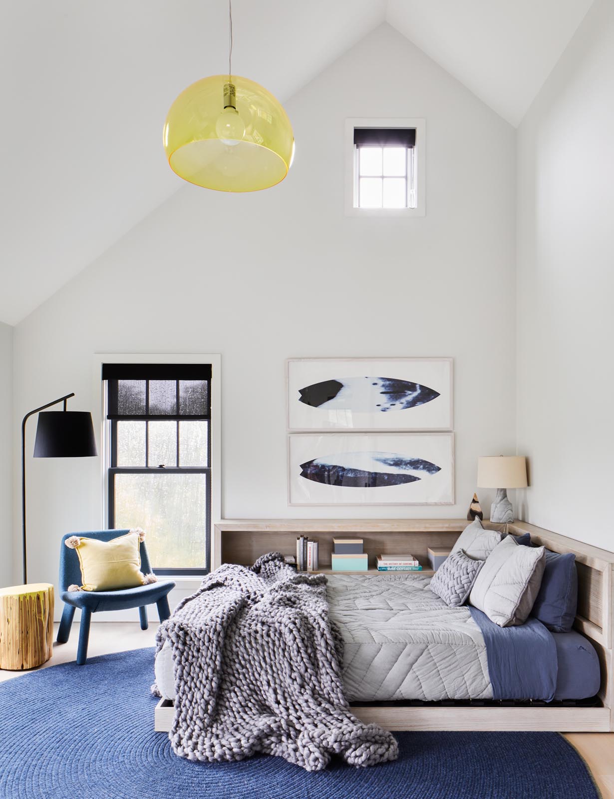 A modern bedroom with a wood bed frame that includes a shelf for books.