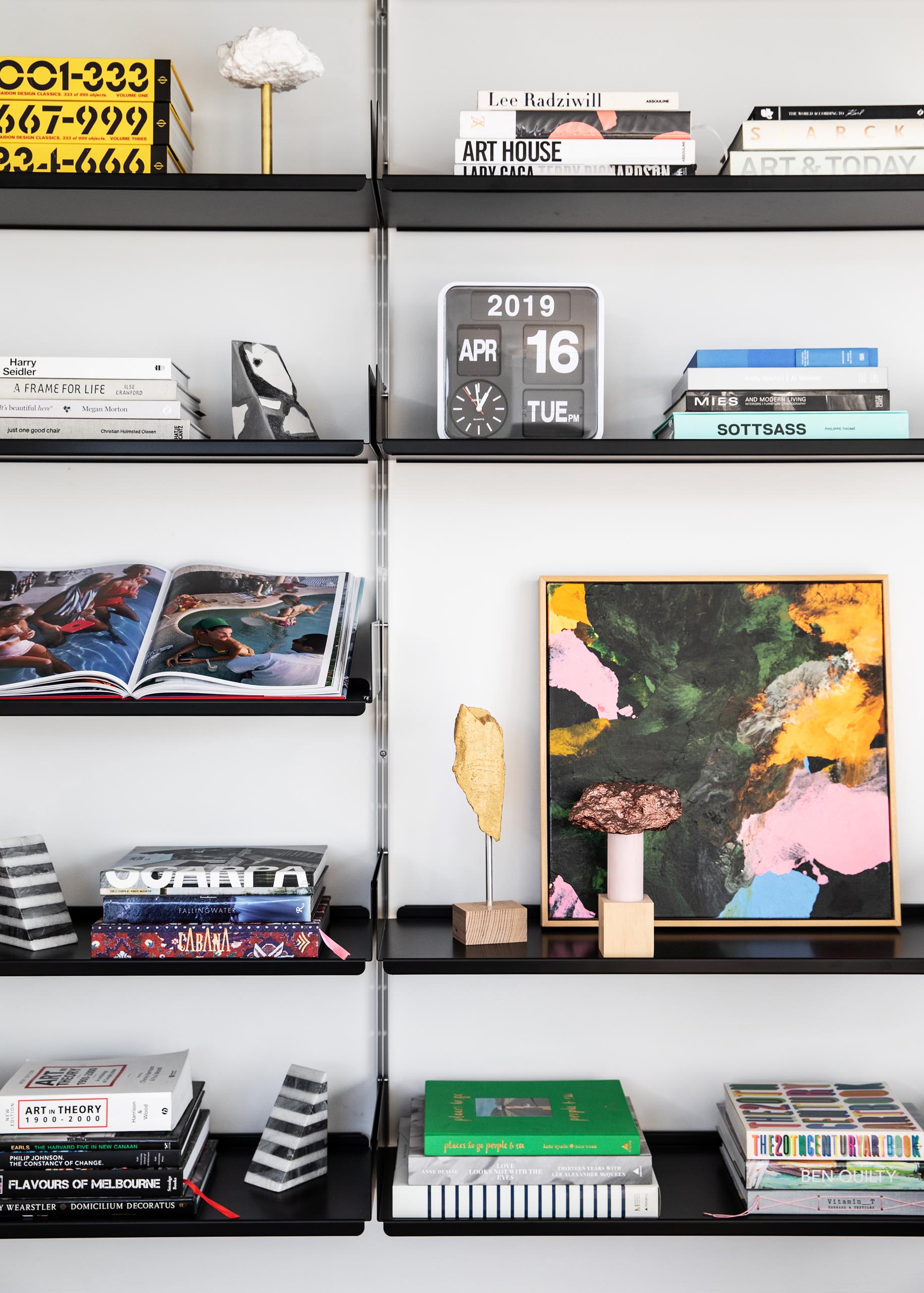 A wall-mounted bookcase with black  shelves.