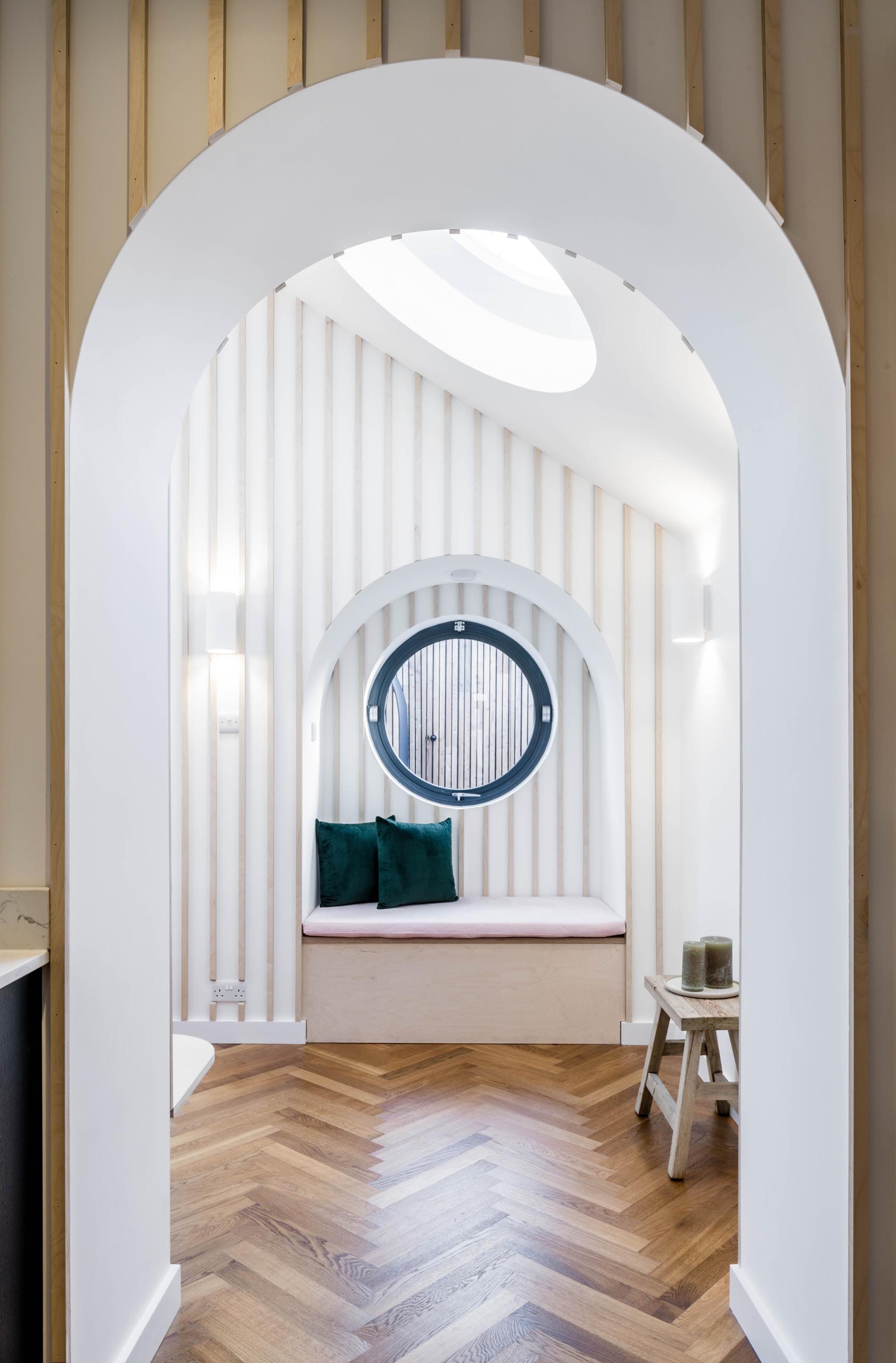 A built-in window bench sits below a round black-framed window.