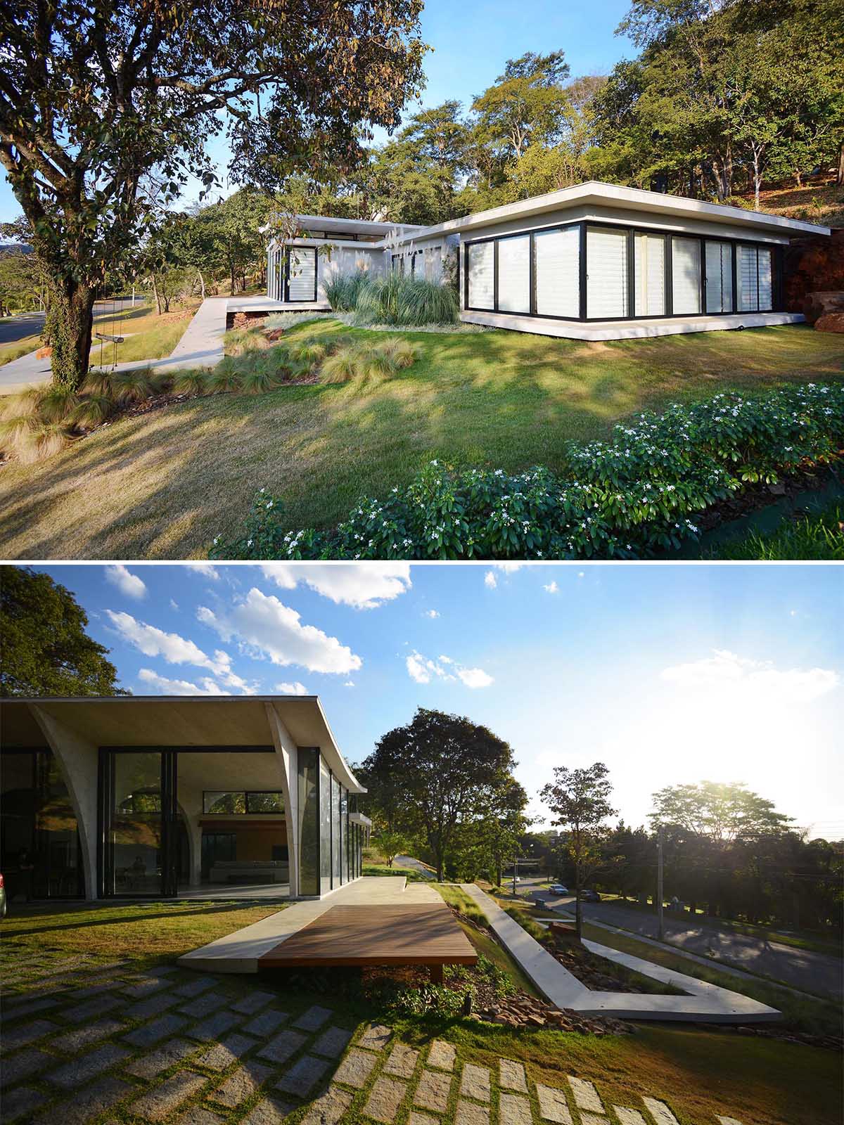 At the front of this modern home, there's a winding concrete path that's lit up at night, guiding people from the road up to the front door.