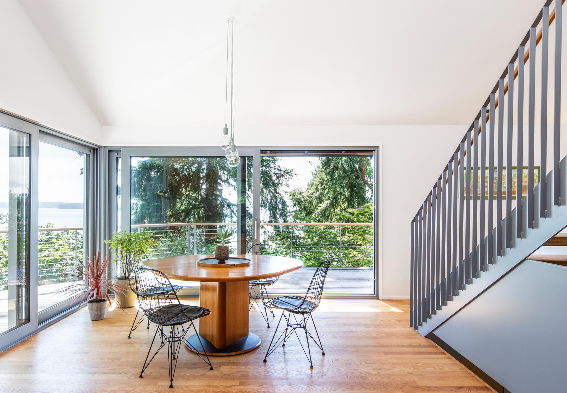 A dining room with a round wood table and sliding doors that open to the balcony.