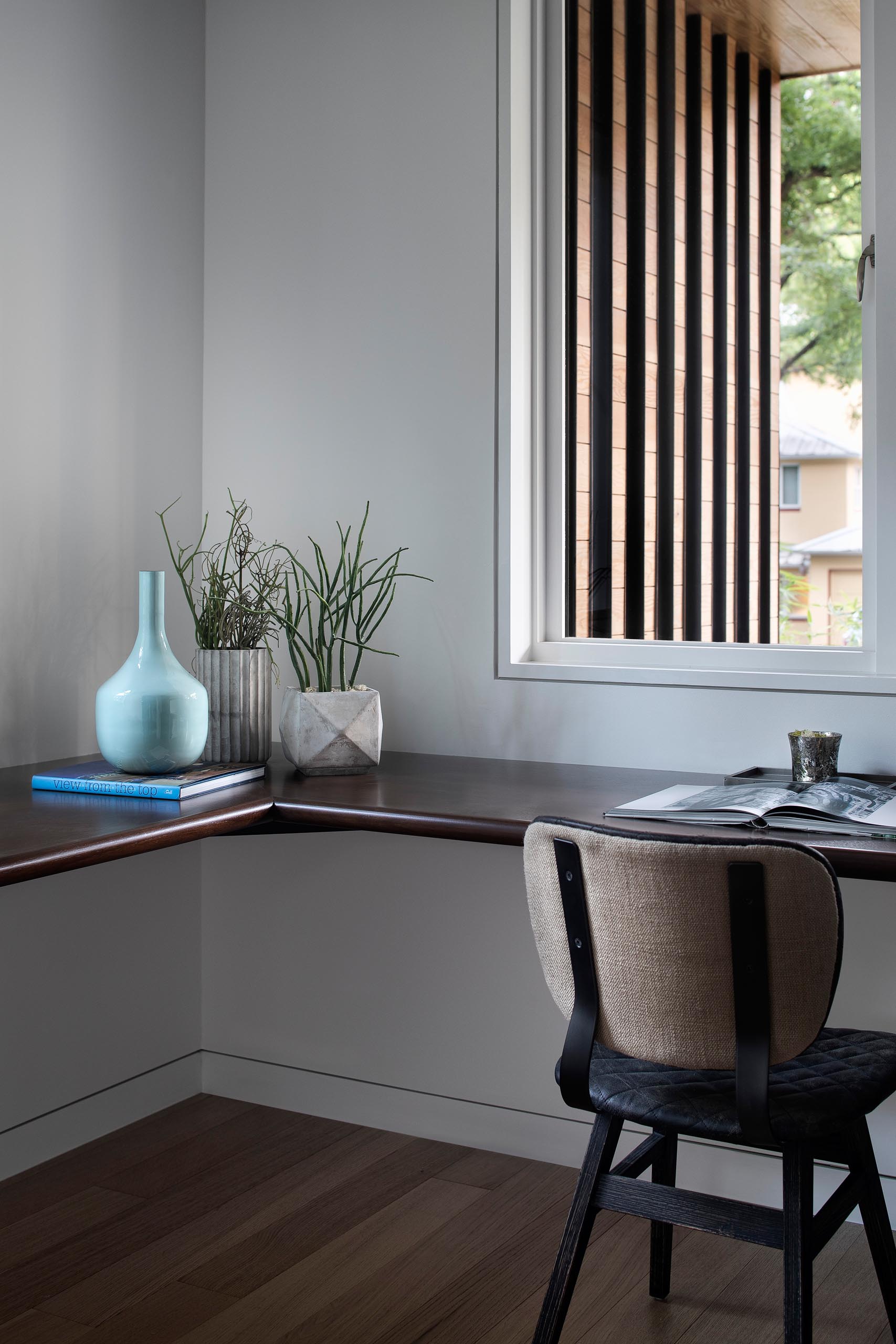 A modern home office with a dark wood floating desk.