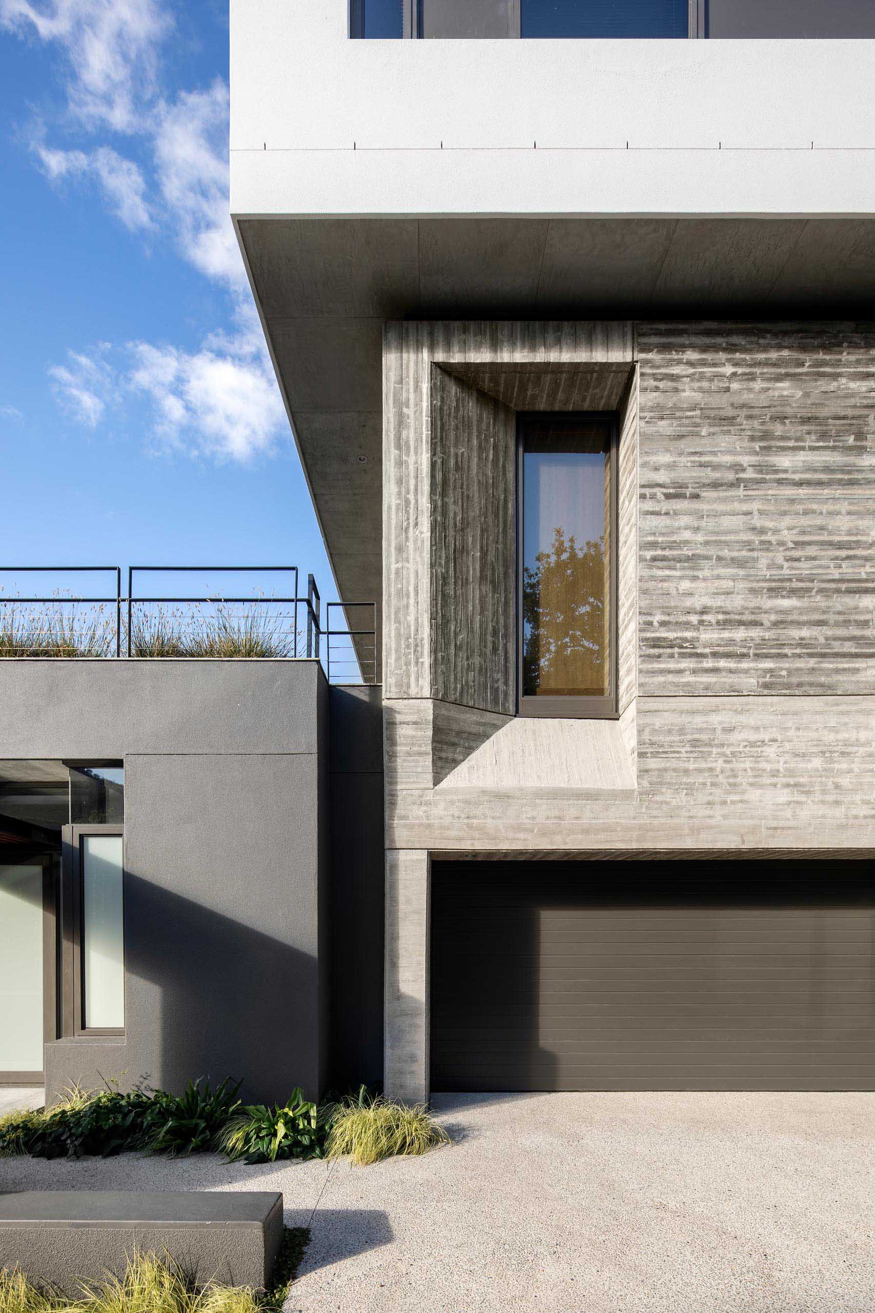 A modern house with a concrete and black exterior.