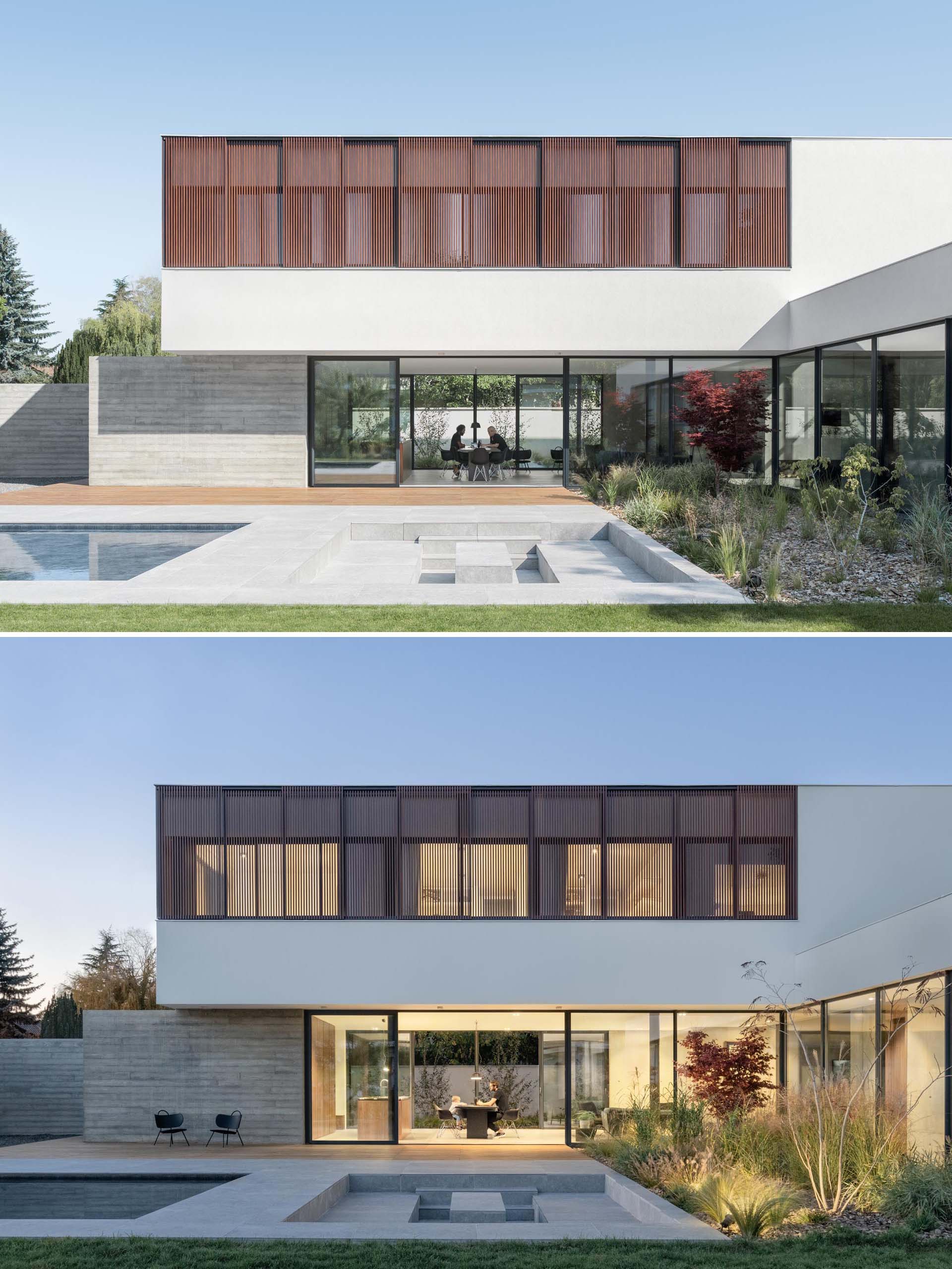 Large sliding glass windows transforming the living room into a huge terrace opening onto a green space, erasing the separation between inside and outside.