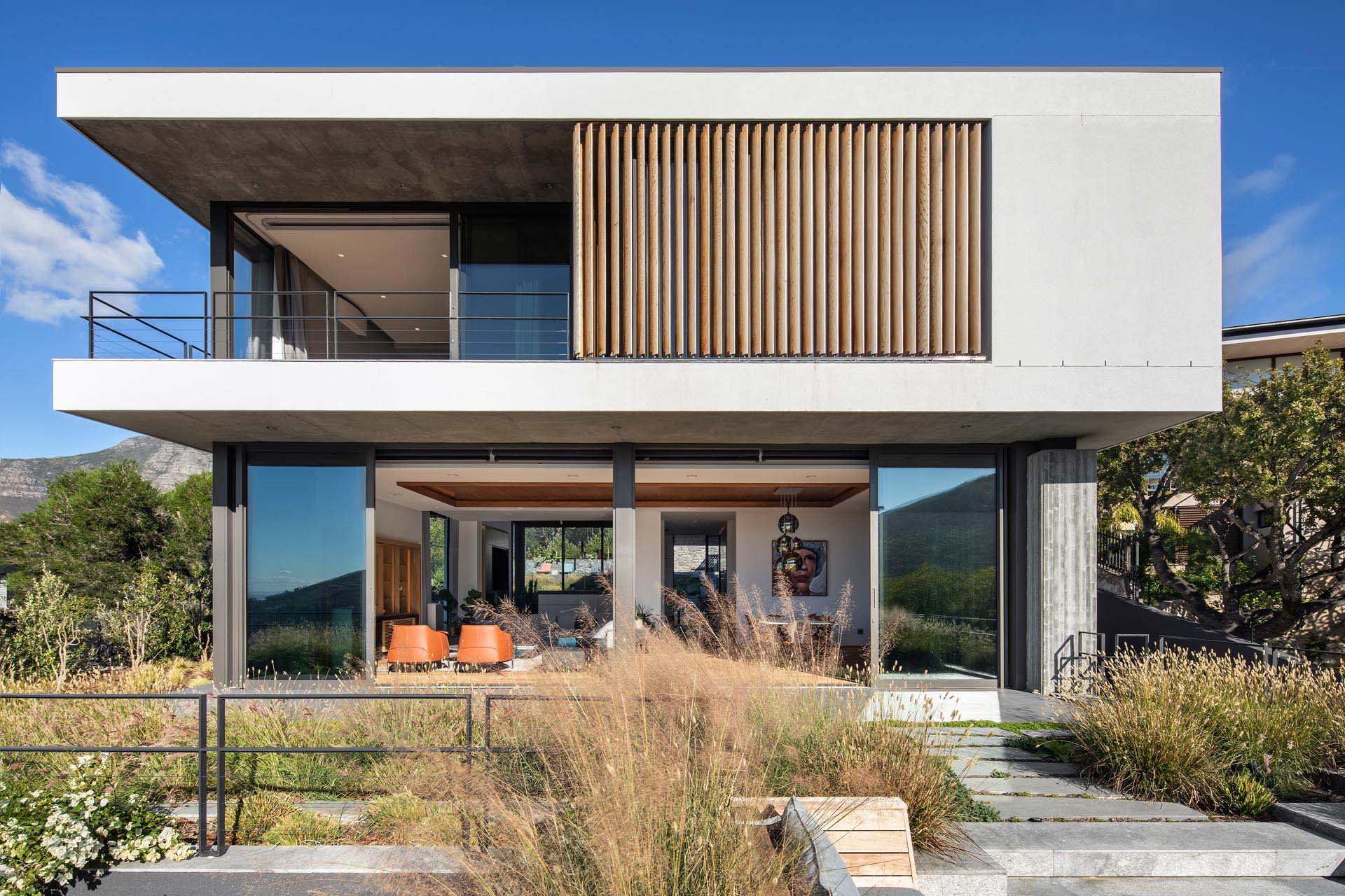 A modern home with an upper level that has wood slats and a covered balcony.