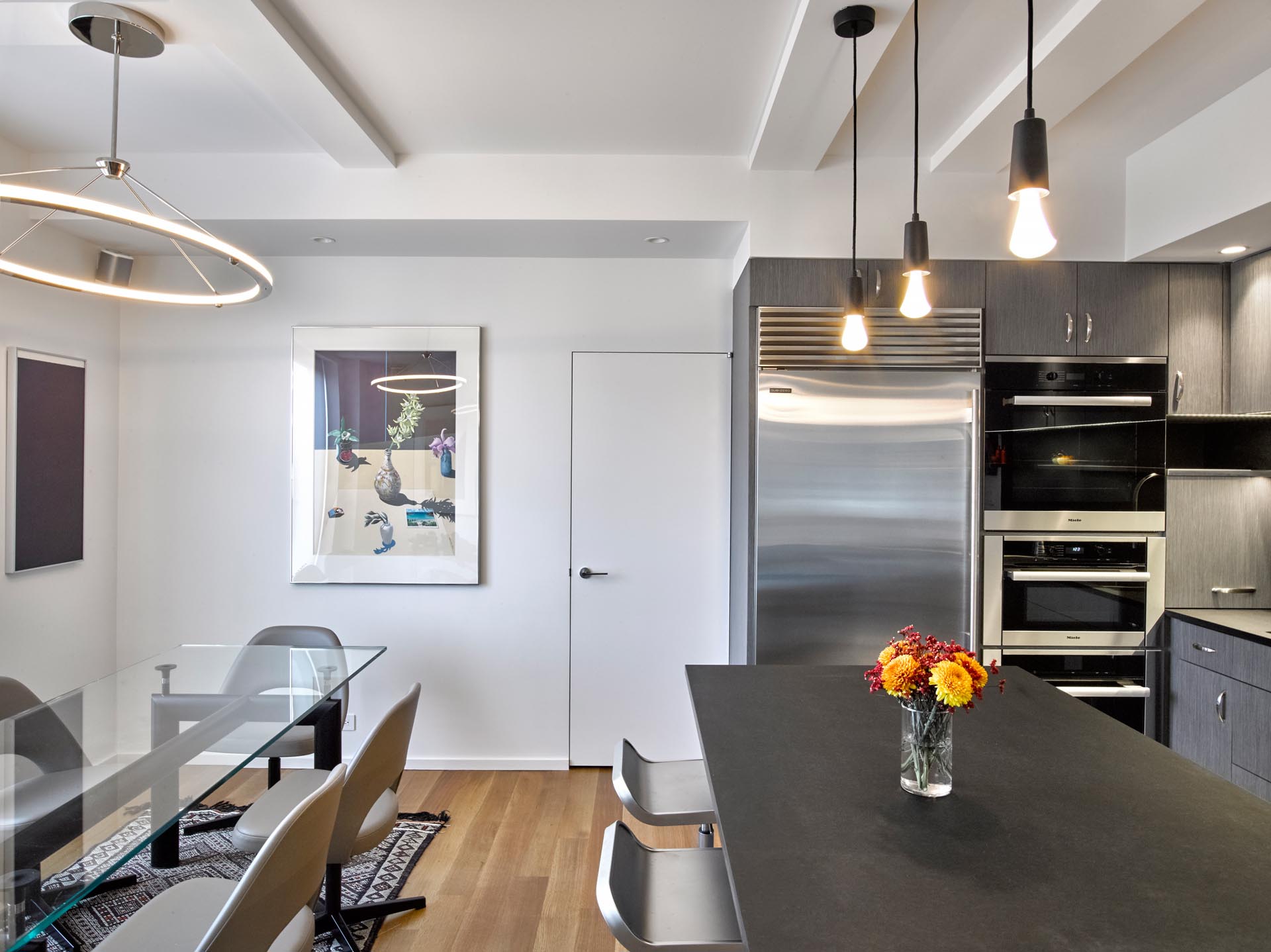 A modern kitchen with gray cabinets, LED undermount lighting, and Paperstone countertops and backsplash.