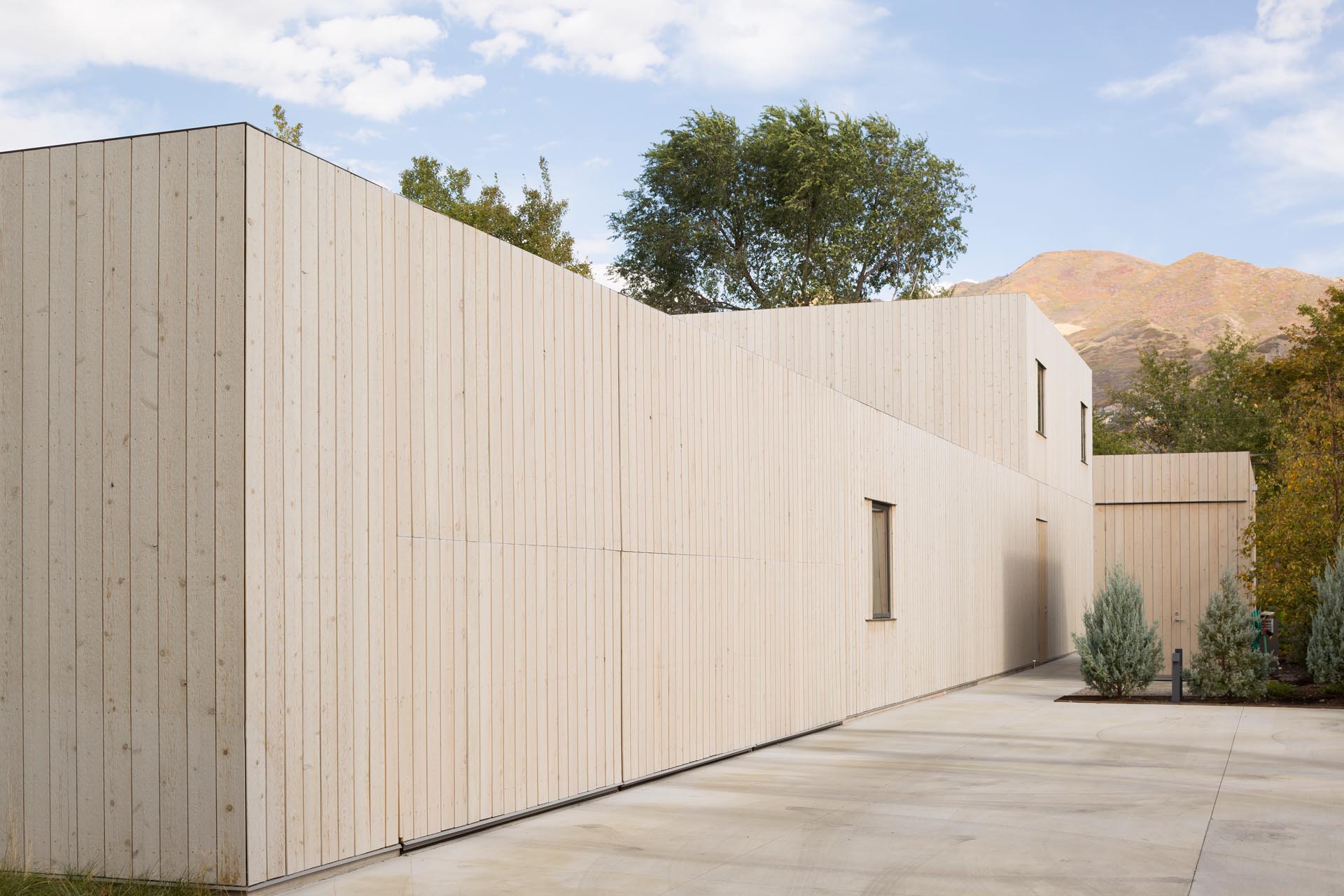 A modern cedar clad house with a matching garage that has hidden doors.