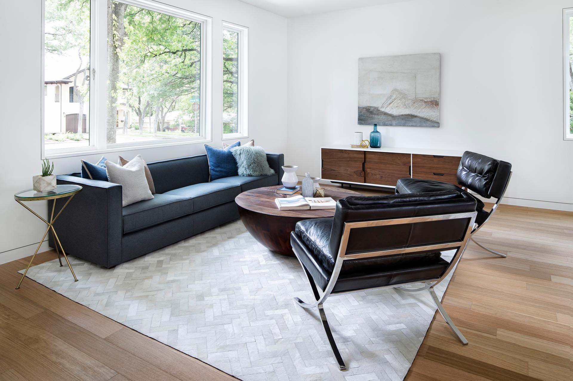 Large windows in this living room provide a view of the street and let the natural light filter through to the interior of the home.