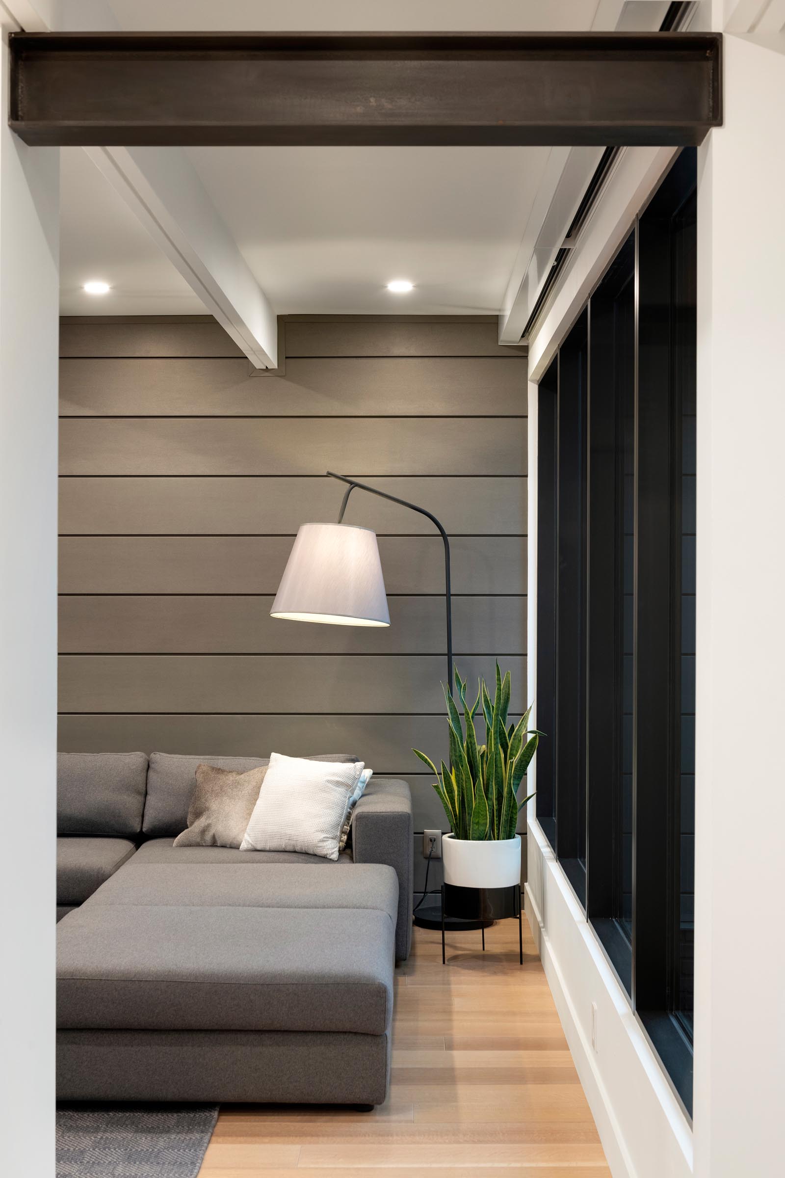 A modern living room with a gray paneled wall and matching sofa.
