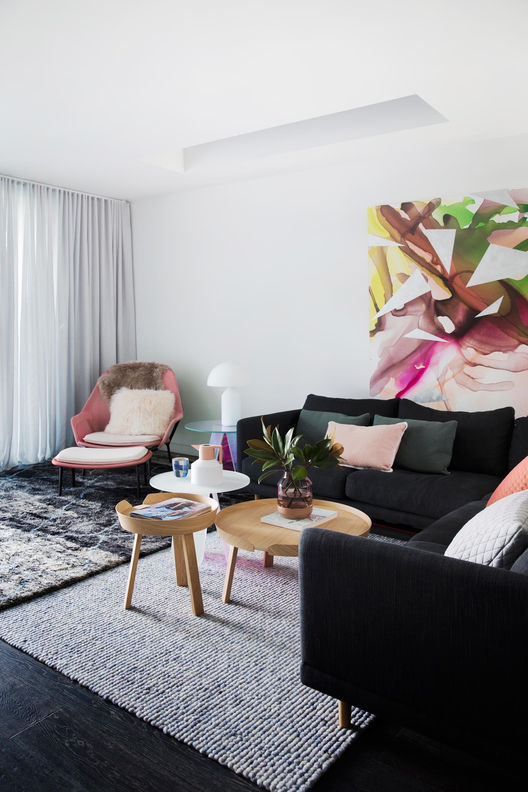 A modern living room with blush pink decorative accents.