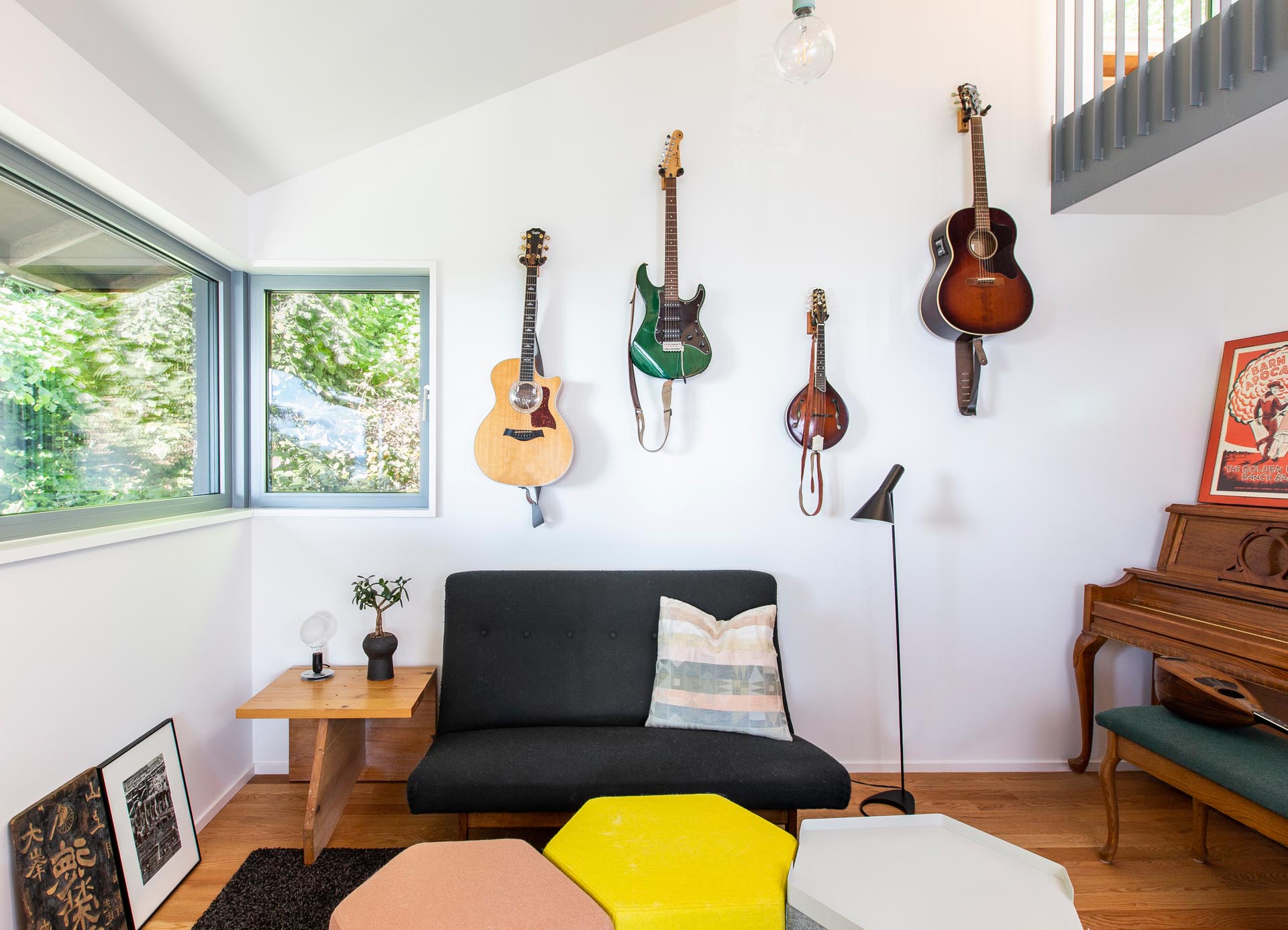 Tucked away in a small nook off a living room is a music corner, with hanging guitars, a piano, and a small sofa.
