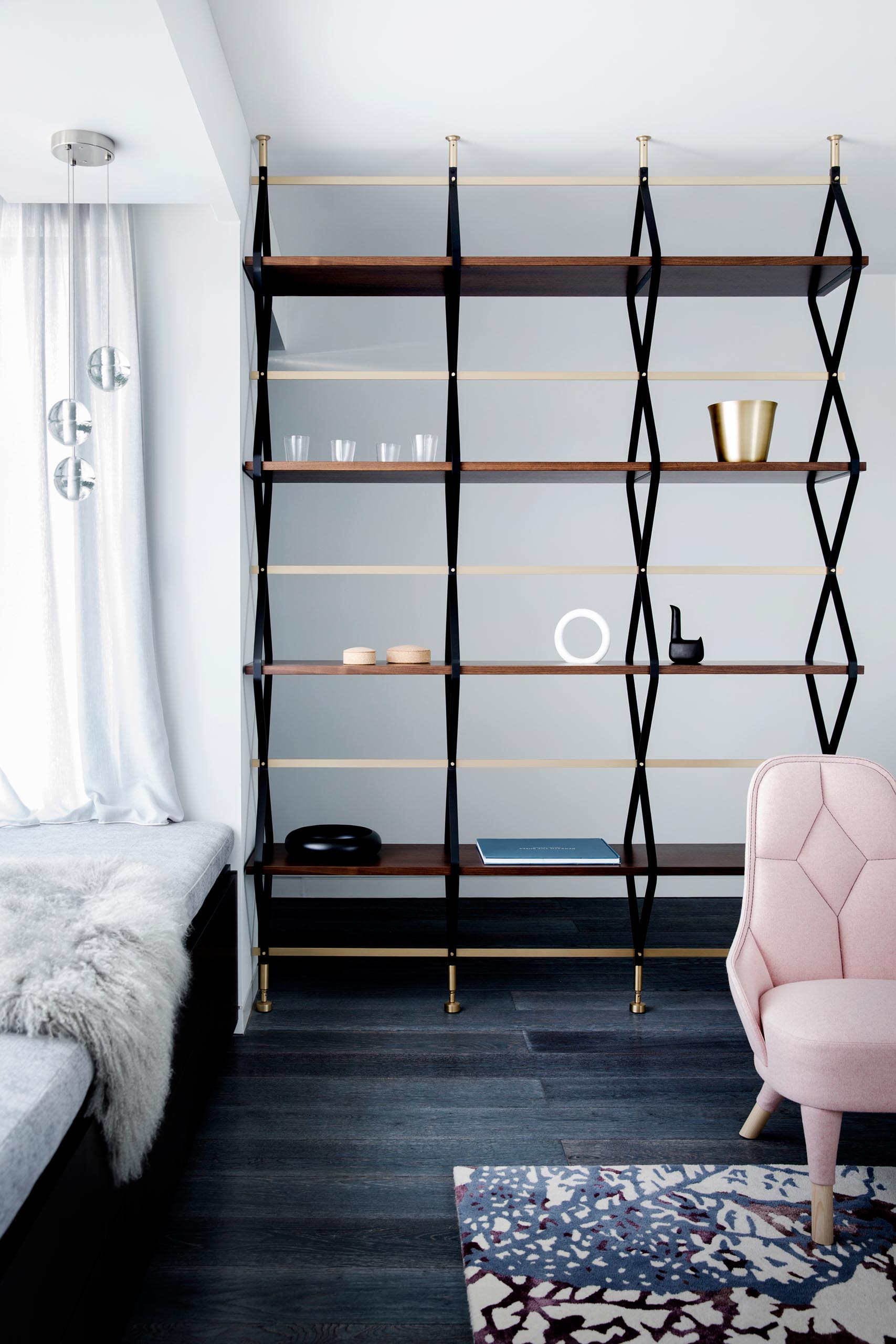 A modern and open shelving unit that acts as a room divider between the living room and entryway.