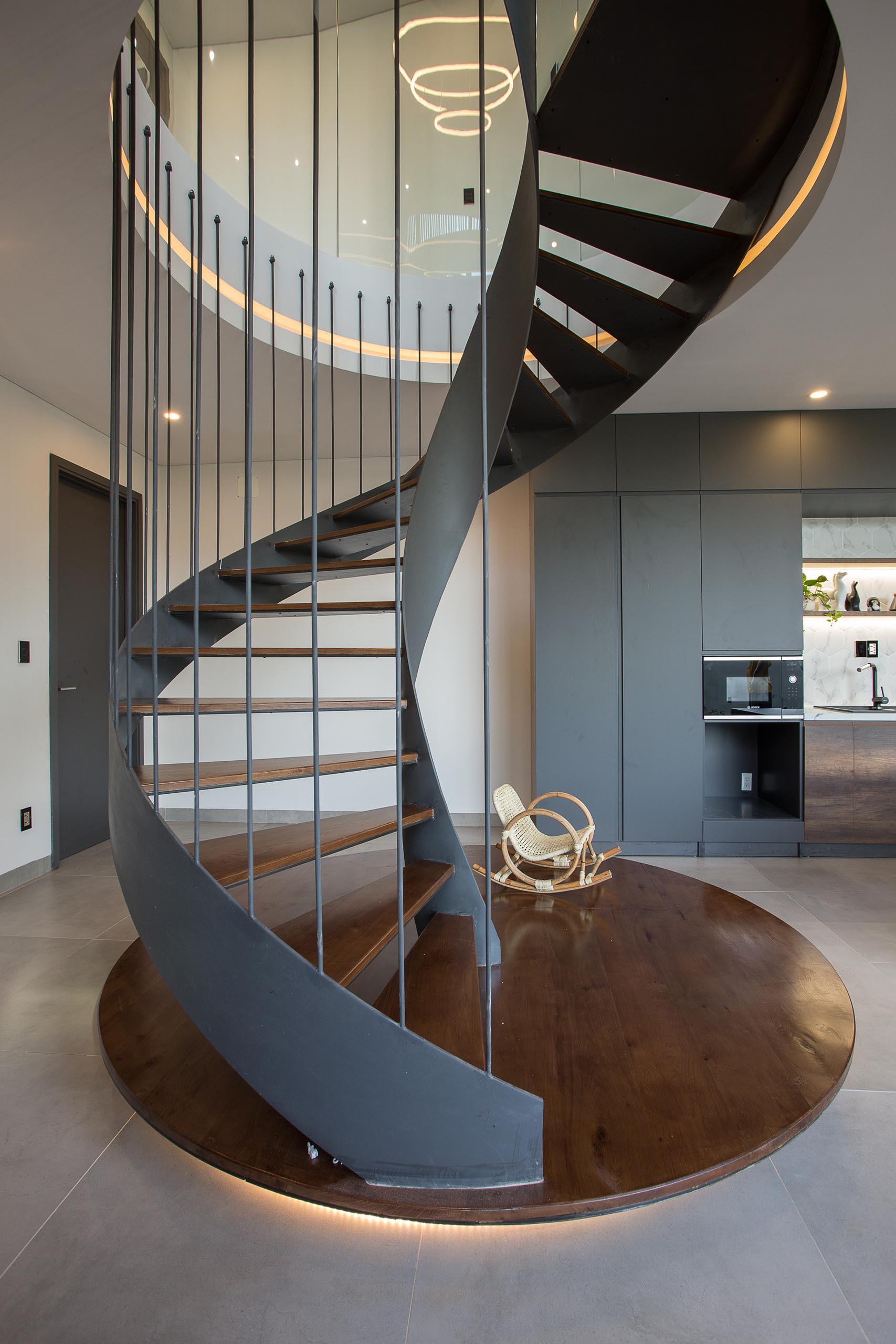 A modern home with black spiral stairs.