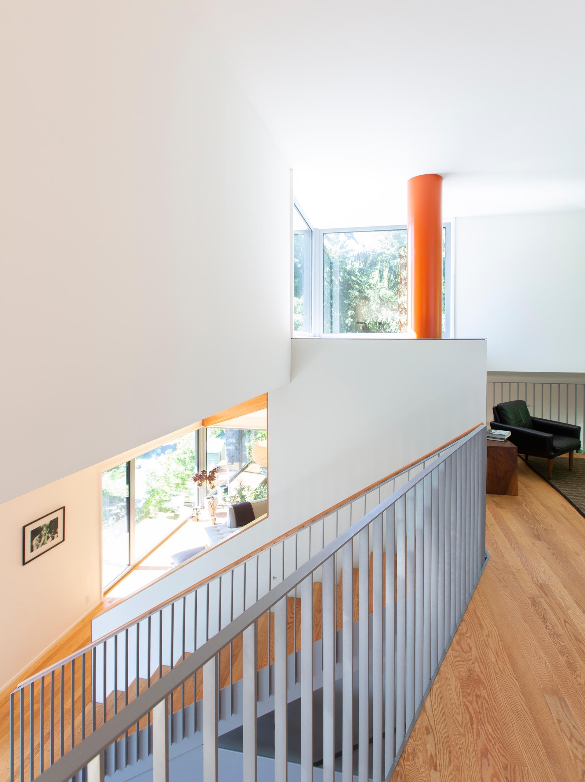 Matte gray and wood stairs connect the main level of this modern home with the upper floor.