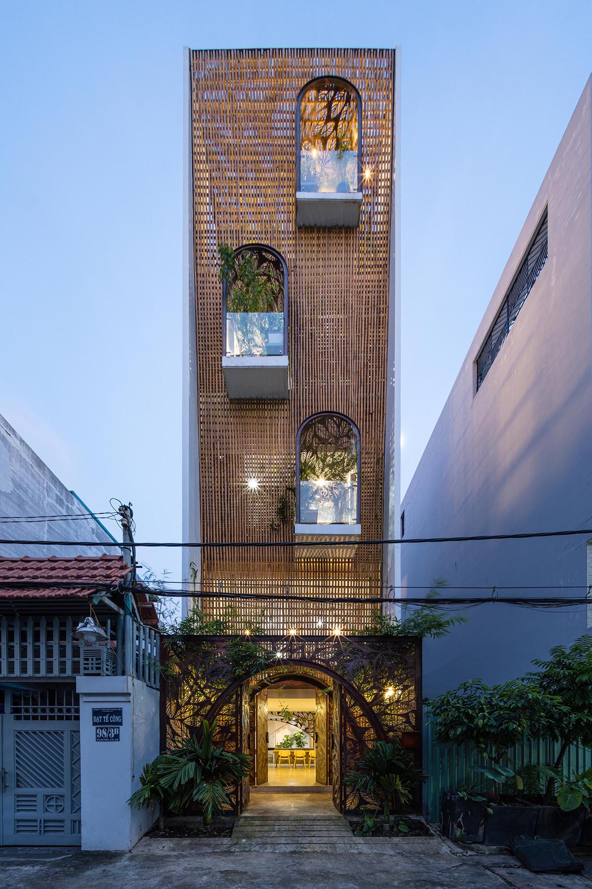 A modern home in Vietnam that has decorative metal screens with a leaf motif.