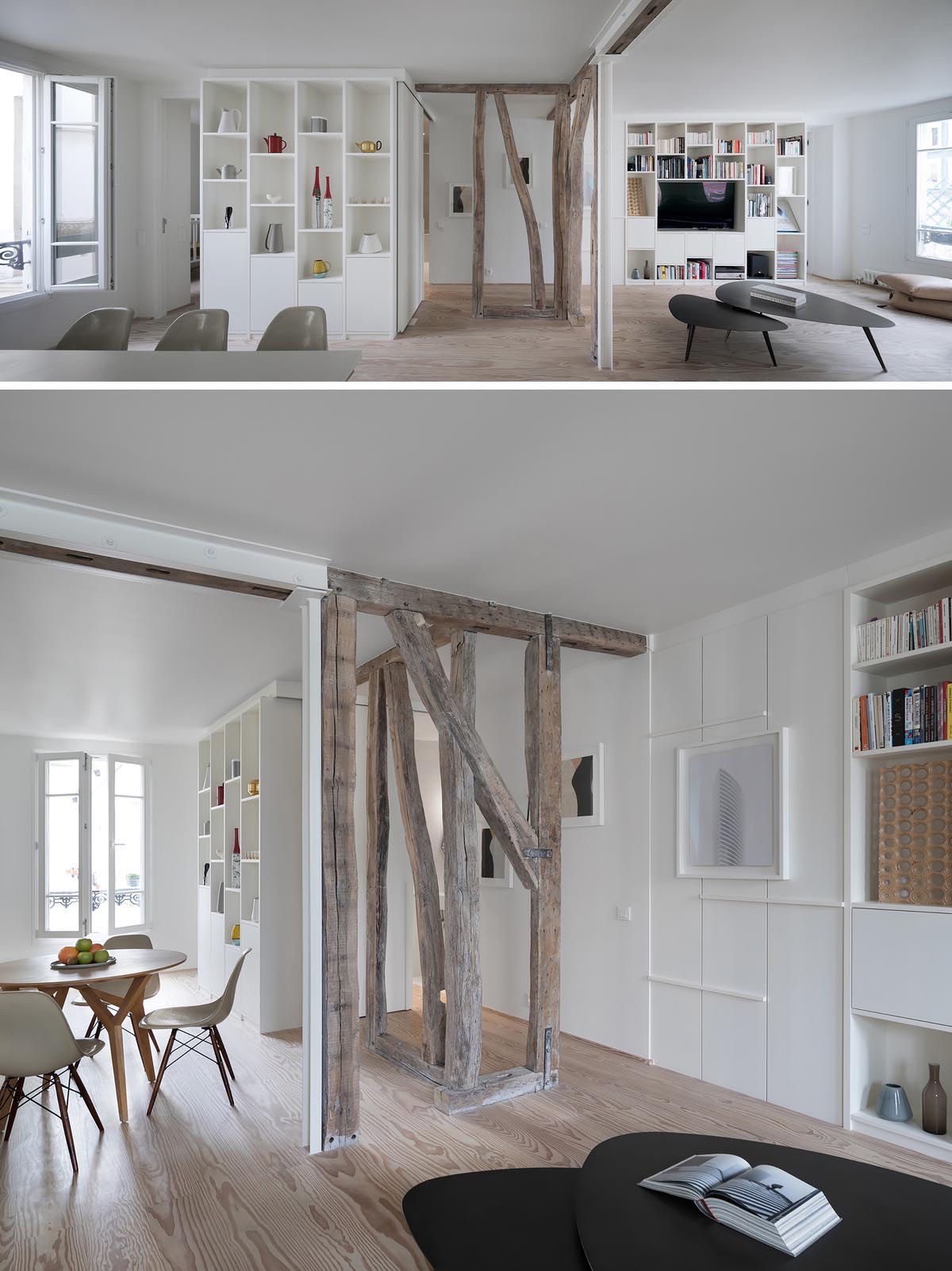 A modern open plan apartment with exposed wooden structure, built-in shelving, and a white color theme.
