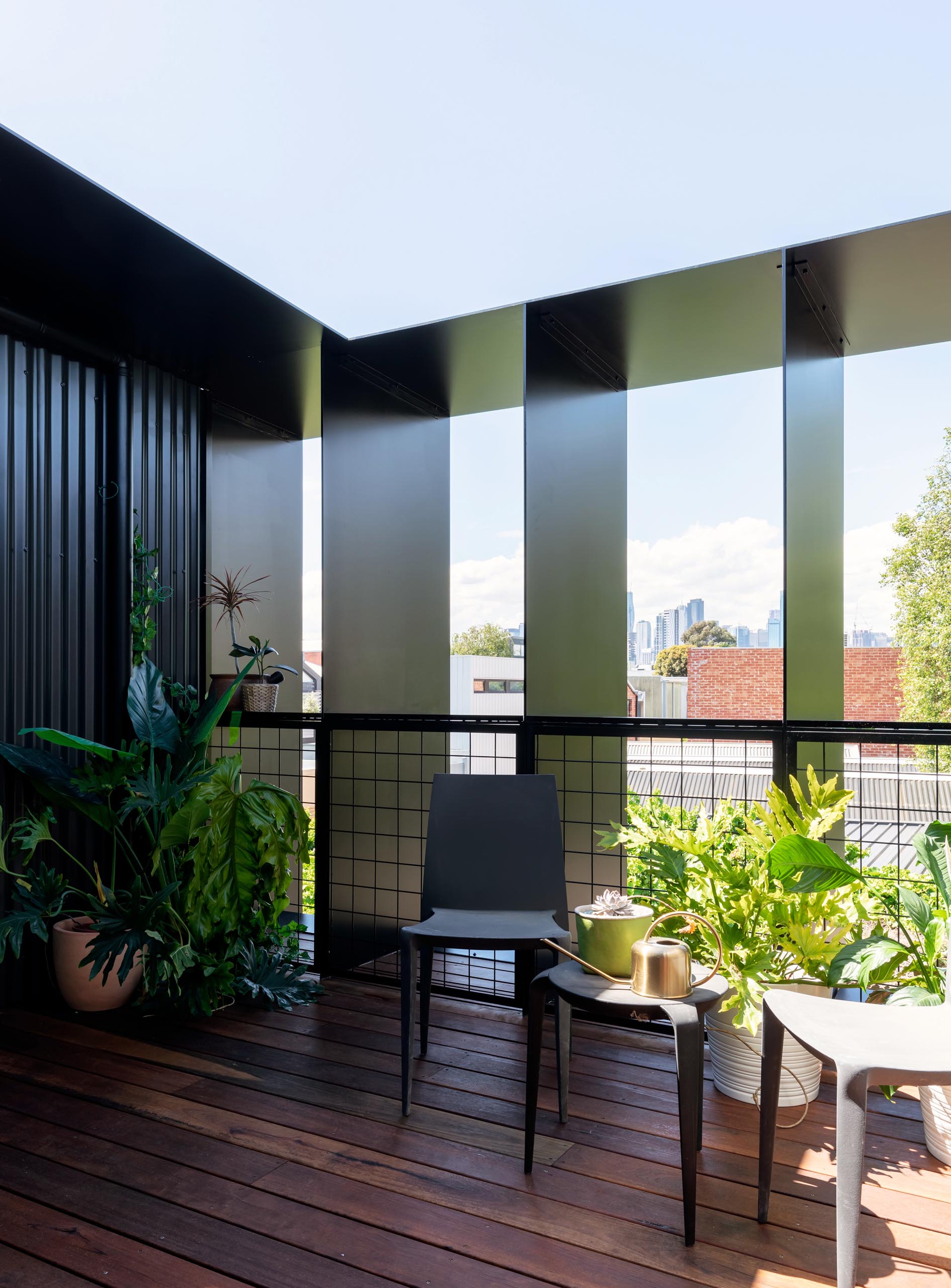 A semi-private deck with wood flooring and corrugated metal siding.