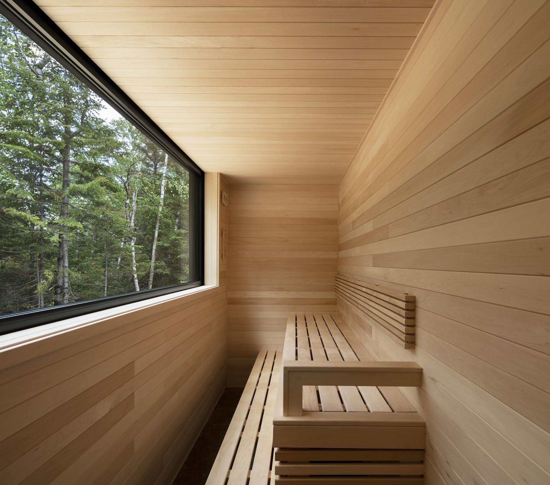 A modern wood-lined sauna with a large window.