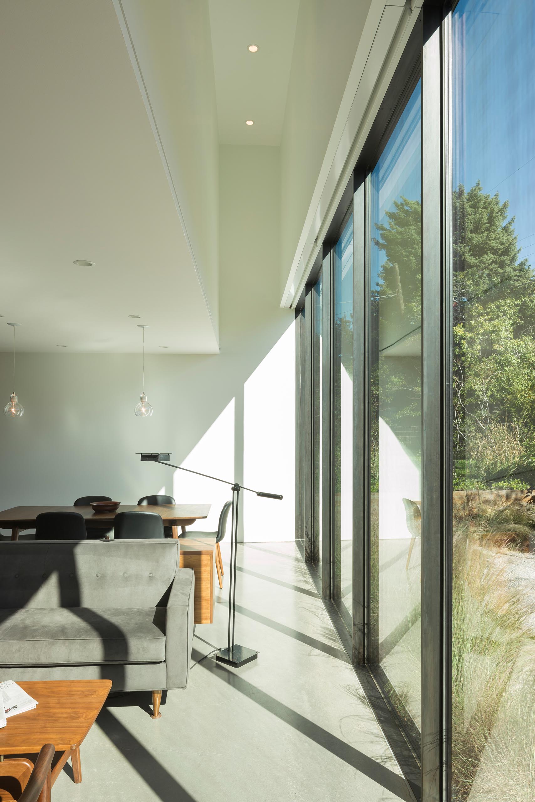 An open plan living room and dining room with a wall of windows.