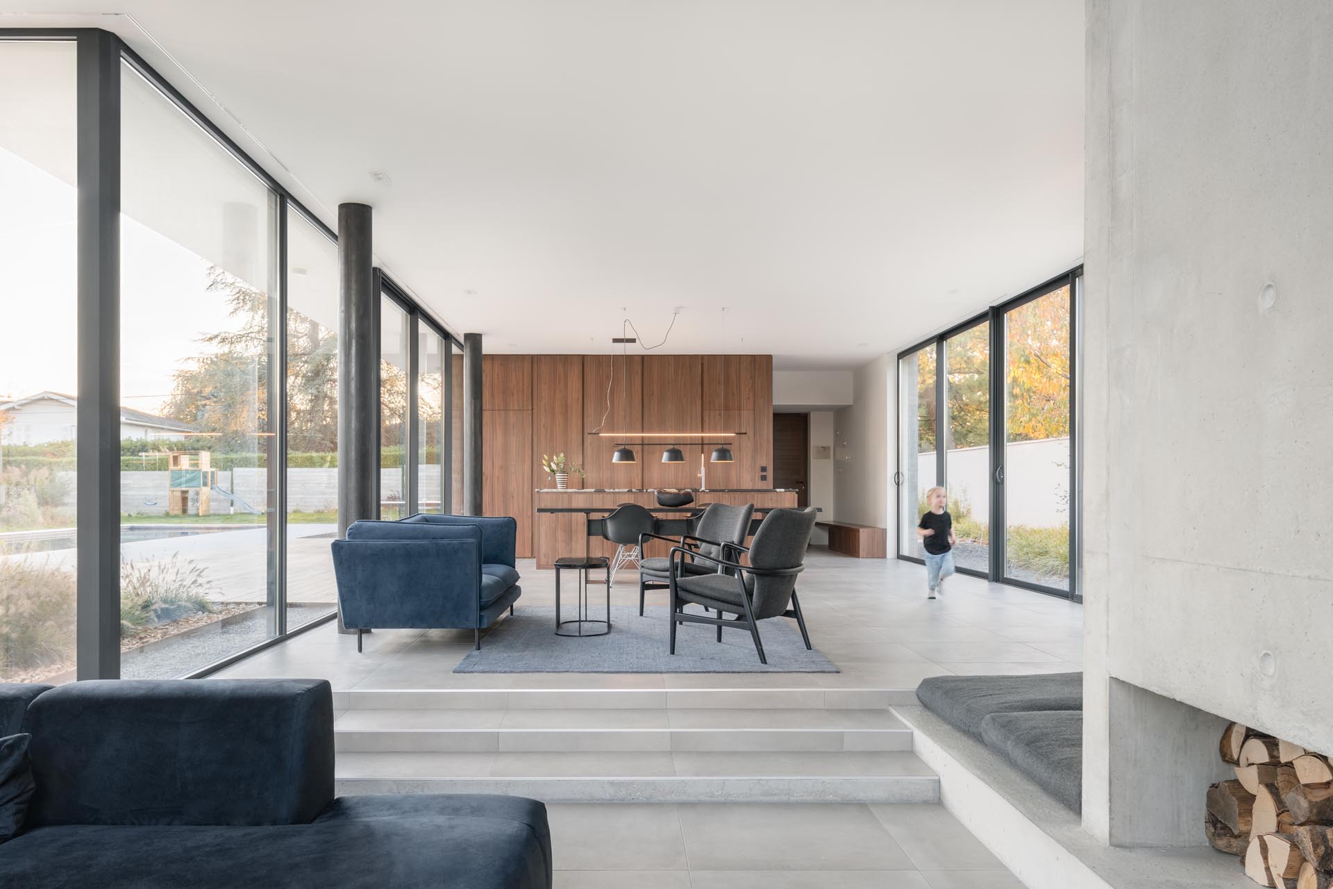 The living and dining areas of this modern home are open plan, with a few steps separating the two spaces. There's also a small ledge that's a dedicated space for a dog bed.