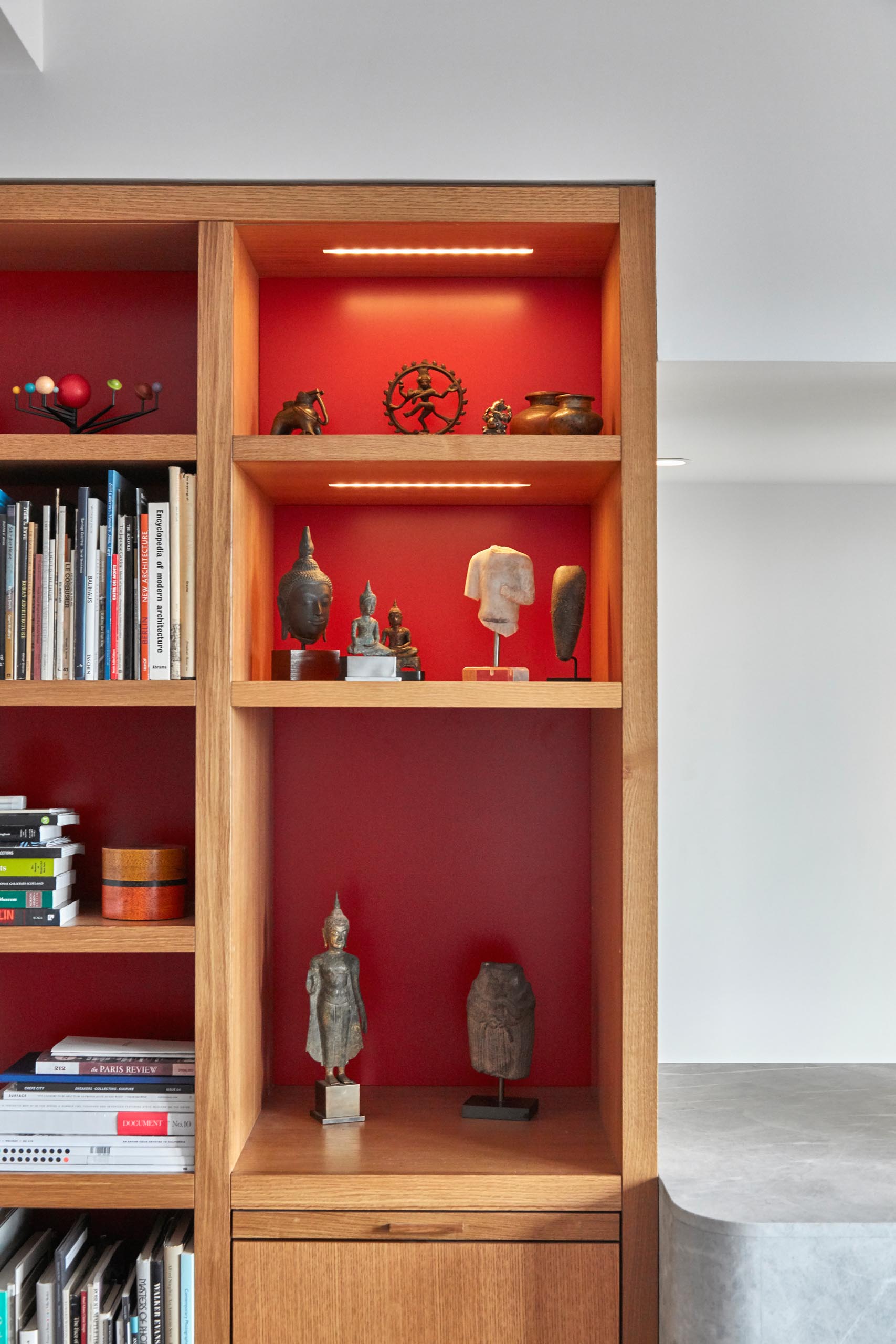 Wood shelves with a red backing and LED lighting.