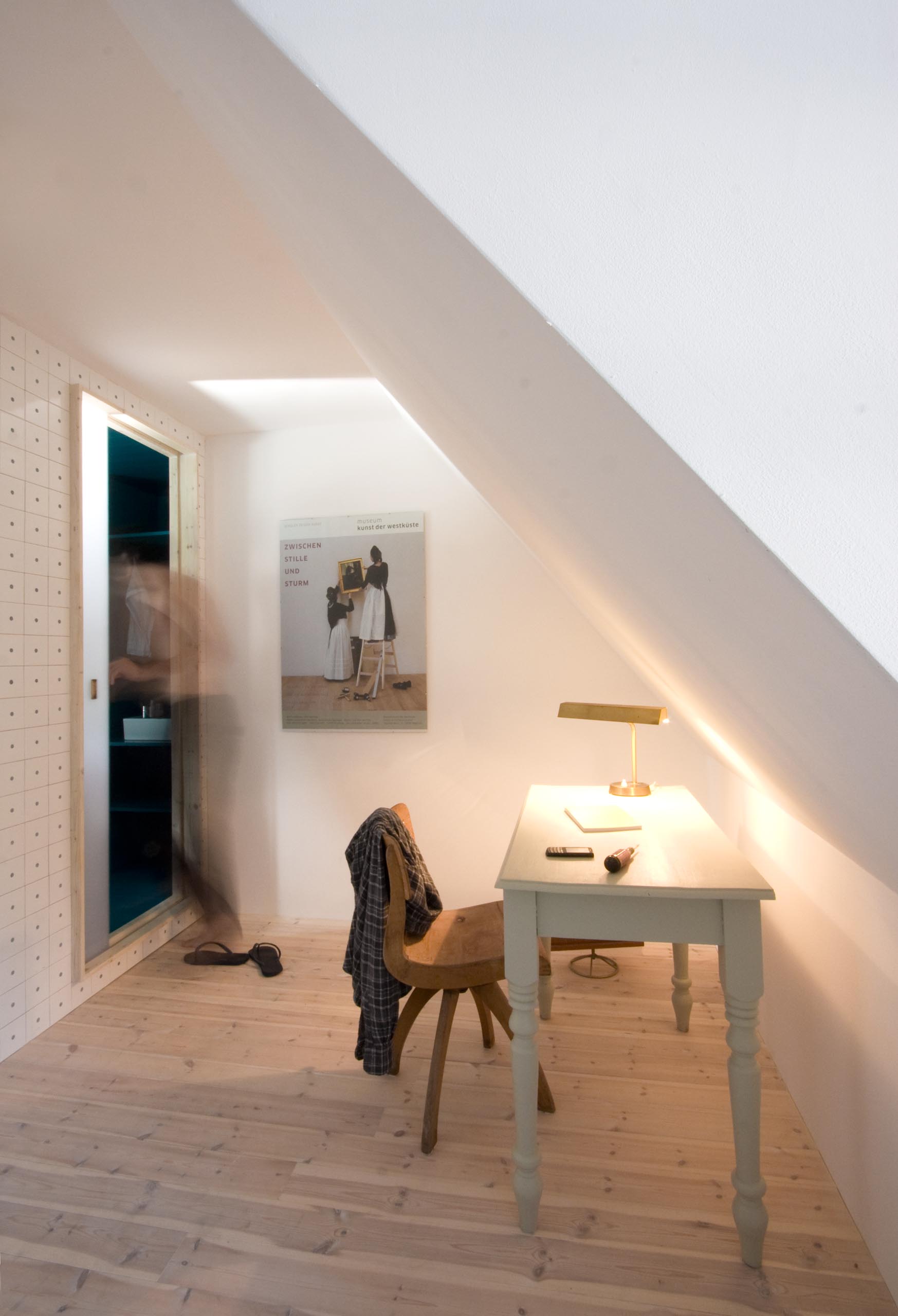 A small home office with an angled ceiling.